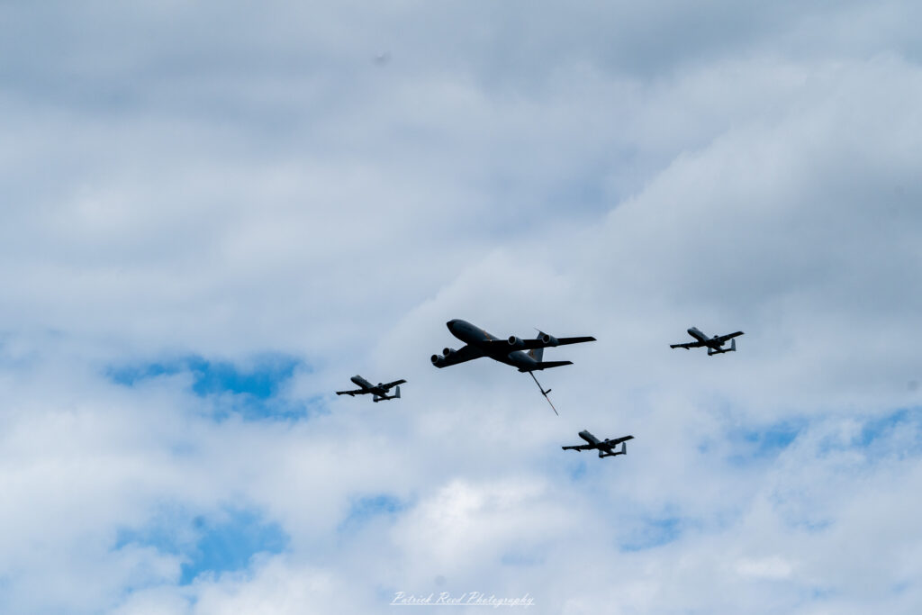 "Three A-10 Warthogs in mid-air during a refueling operation, showcasing a stunning aerial formation. The aircraft are flying in close proximity, with the lead A-10 positioned near a KC-135 Stratotanker, which is extending its refueling boom. The rugged design of the A-10 is highlighted, with its iconic nose-mounted cannon and camouflage paint scheme. As the jets receive fuel, the scene captures the precision and teamwork involved in aerial refueling, set against a backdrop of clear blue skies. The image emphasizes the strategic capabilities of the A-10 and its reliance on mid-air refueling to extend its operational range and mission effectiveness."