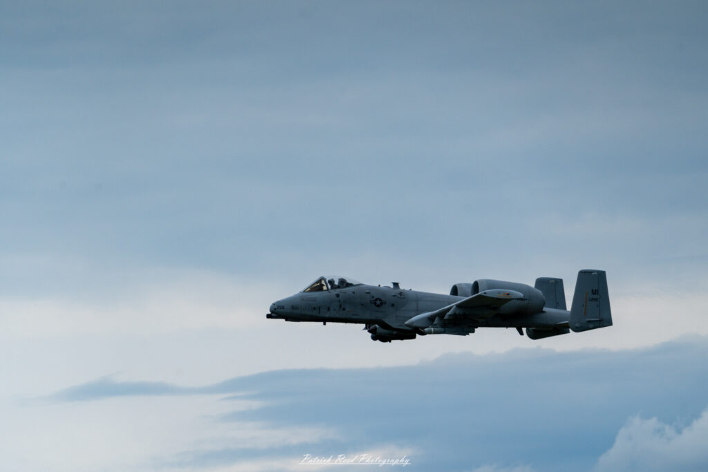 "The A-10 Warthog, officially known as the A-10 Thunderbolt II, is depicted in a powerful stance on the runway, showcasing its rugged design and formidable presence. The aircraft features a distinctive twin-engine configuration, a wide wingspan, and a heavily armored fuselage designed for close air support. Its prominent GAU-8/A Avenger cannon is visible on the nose, emphasizing its role in delivering devastating firepower against ground targets. The A-10 is painted in a camouflage pattern, with the U.S. Air Force insignia and squadron markings adorning its sides. This iconic aircraft is known for its durability, low-altitude capabilities, and ability to operate in challenging environments, making it a beloved asset among military aviation enthusiasts."