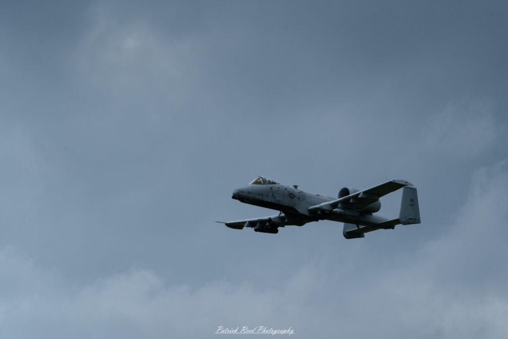 "The A-10 Warthog, officially known as the A-10 Thunderbolt II, is depicted in a powerful stance on the runway, showcasing its rugged design and formidable presence. The aircraft features a distinctive twin-engine configuration, a wide wingspan, and a heavily armored fuselage designed for close air support. Its prominent GAU-8/A Avenger cannon is visible on the nose, emphasizing its role in delivering devastating firepower against ground targets. The A-10 is painted in a camouflage pattern, with the U.S. Air Force insignia and squadron markings adorning its sides. This iconic aircraft is known for its durability, low-altitude capabilities, and ability to operate in challenging environments, making it a beloved asset among military aviation enthusiasts."