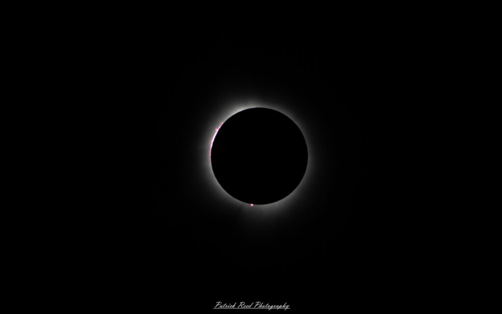 "Bailey's Beads effect during a solar eclipse, where small beads of sunlight shine through the rugged valleys and mountains on the moon's surface just before and after totality. These bright points of light create a sparkling, bead-like appearance along the edge of the moon's silhouette, against the darkened sky. The contrast between the beads and the encroaching shadow of the moon highlights the intricate interplay between light and shadow in this unique and fleeting astronomical phenomenon."