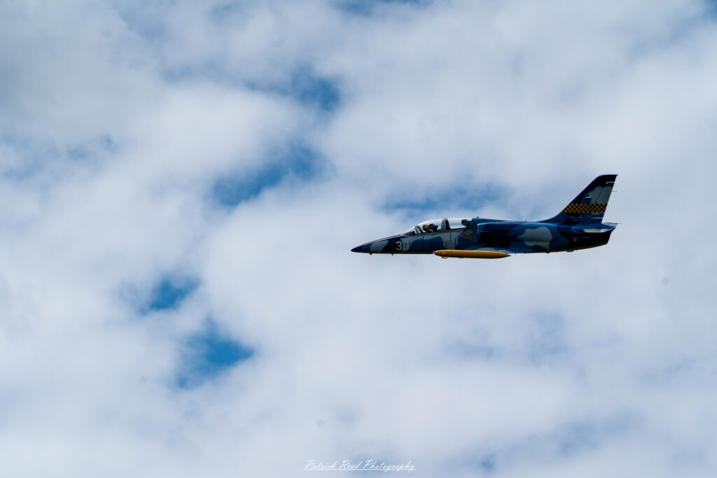 "A fighter jet in flight, soaring through a clear blue sky, showcasing its sleek and aerodynamic design. The aircraft features sharp angles and a streamlined body, often adorned with military insignia and a distinctive paint scheme. Its wings are positioned for optimal performance as it maneuvers gracefully, with contrails streaming behind it. The jet's powerful engines emit a faint roar, emphasizing its speed and agility. This dynamic image captures the essence of modern military aviation, highlighting the cutting-edge technology and capabilities of contemporary fighter jets."