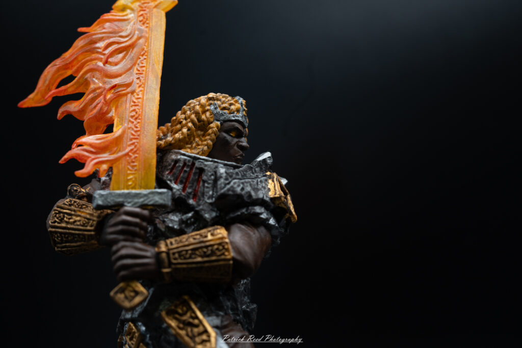 "A hand-painted Dungeons & Dragons miniatures figure of a fire giant, showcasing intricate details in its armor and fiery features. The figure is vividly colored with shades of red, orange, and yellow to represent flames, and its expression conveys a sense of strength and menace. The base of the mini features elements that reflect a volcanic or fiery environment, enhancing the overall thematic appearance."