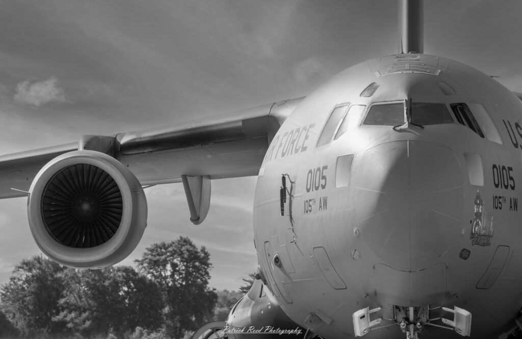 "The Air Force Globemaster, a large military transport aircraft, is depicted in an impressive profile view during flight. This aircraft features a wide wingspan and a distinctive nose that can be raised for loading cargo. Its sleek design is accentuated by military markings and a camouflaged paint scheme, highlighting its role in airlift and logistical support. The Globemaster is shown soaring through a clear blue sky, with its engines roaring and contrails streaming behind it, emphasizing its power and capability. This image captures the significance of the Globemaster in modern military operations, showcasing its versatility and strength."