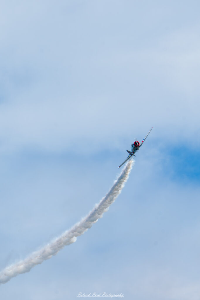 "The T-6 Texan, a classic single-engine advanced trainer aircraft used extensively during World War II and beyond. This iconic plane features a sleek, low-wing design with a distinctive round engine cowling and a two-seat cockpit. The T-6 Texan is often seen with its original military markings, including insignia and serial numbers, painted on its aluminum body. The aircraft's sturdy frame and reliable performance made it a staple in pilot training programs, and its legacy continues as a popular warbird at airshows and in aviation history."