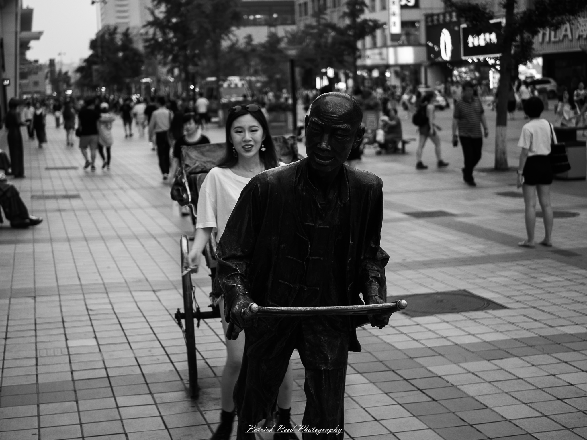 Beijing 4 A series of noir-style street photography scenes set in Beijing, China, at night. The rain-slicked alleys and streets reflect the dim glow of neon signs from small shops, tea houses, and street vendors. Silhouettes of people walking under umbrellas or riding bicycles disappear into the misty night. Traditional hutong architecture with tiled roofs and red lanterns contrasts with modern high-rise buildings and glowing billboards in the distance. The interplay of deep shadows and warm artificial lights creates a cinematic, moody atmosphere, capturing the essence of noir storytelling in the heart of the city.