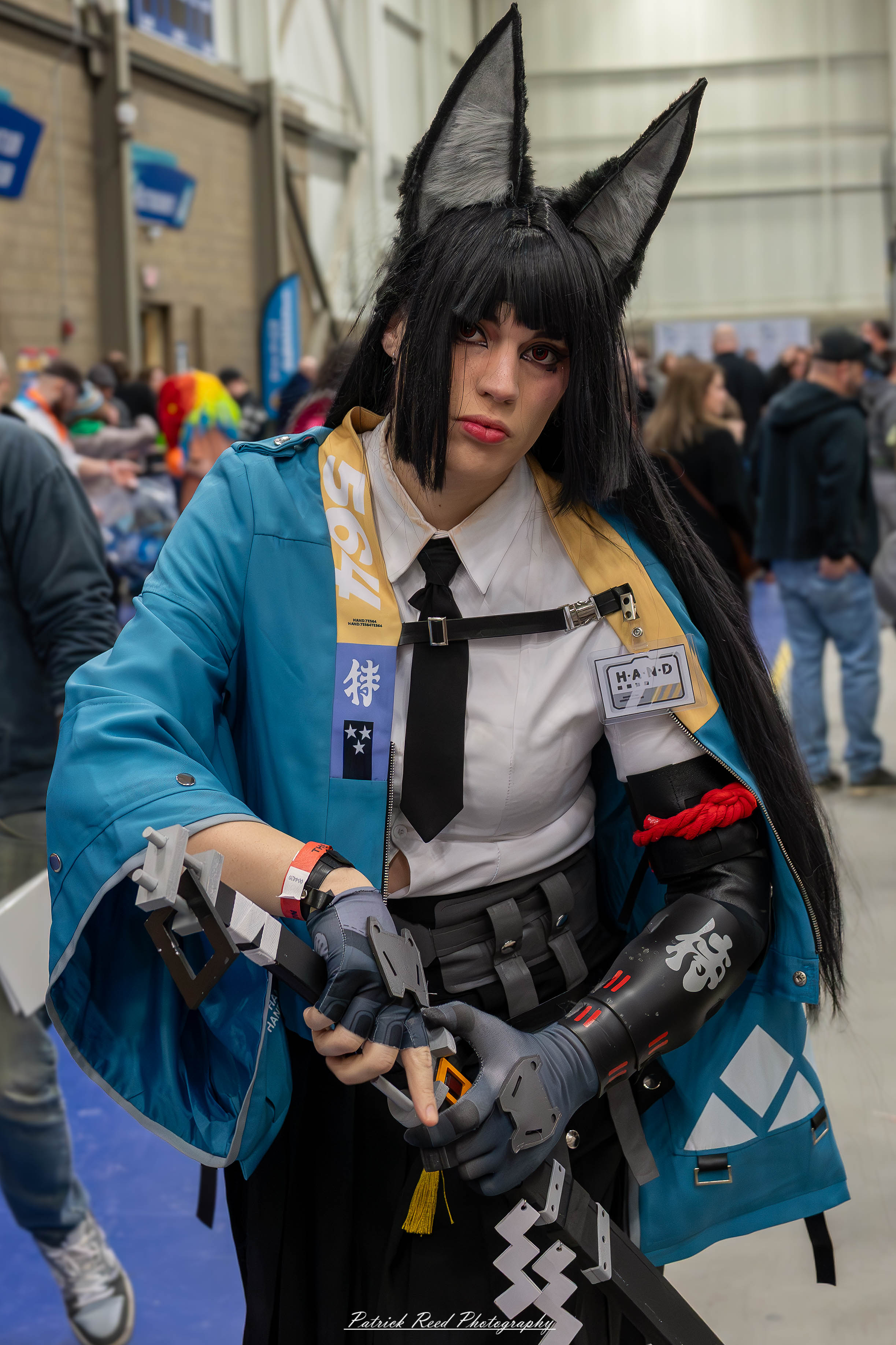 Great Lakes Comic Con 14 Alt text: A group of cosplayers posing on stage at the Great Lakes Comic Con cosplay contest, dressed as various characters from comics, anime, and video games. The audience watches from below as the participants show off their detailed costumes under bright stage lights.