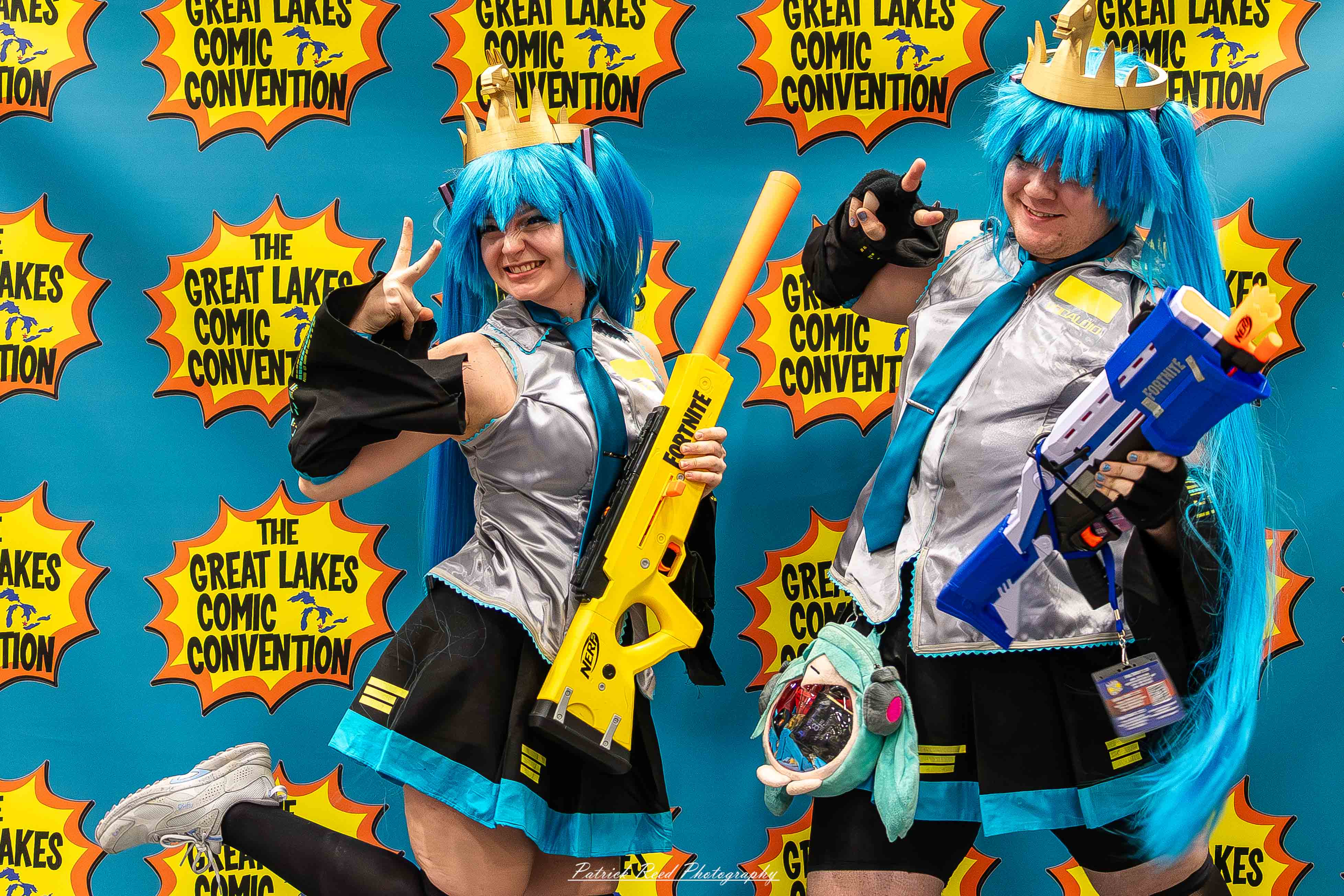 Great Lakes Comic Con 17 Alt text: A group of cosplayers posing on stage at the Great Lakes Comic Con cosplay contest, dressed as various characters from comics, anime, and video games. The audience watches from below as the participants show off their detailed costumes under bright stage lights.