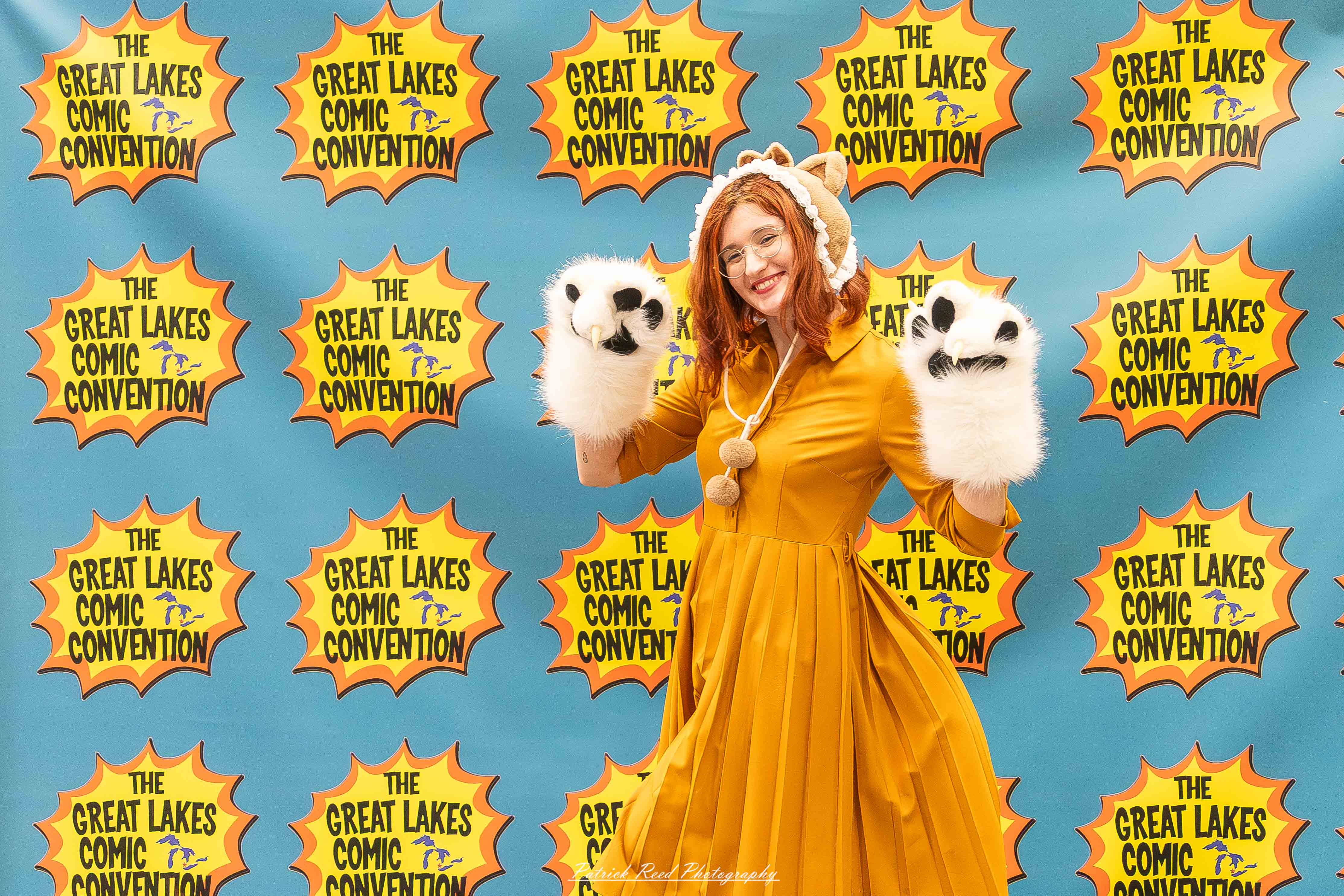 Great Lakes Comic Con 43 Alt text: A group of cosplayers posing on stage at the Great Lakes Comic Con cosplay contest, dressed as various characters from comics, anime, and video games. The audience watches from below as the participants show off their detailed costumes under bright stage lights.