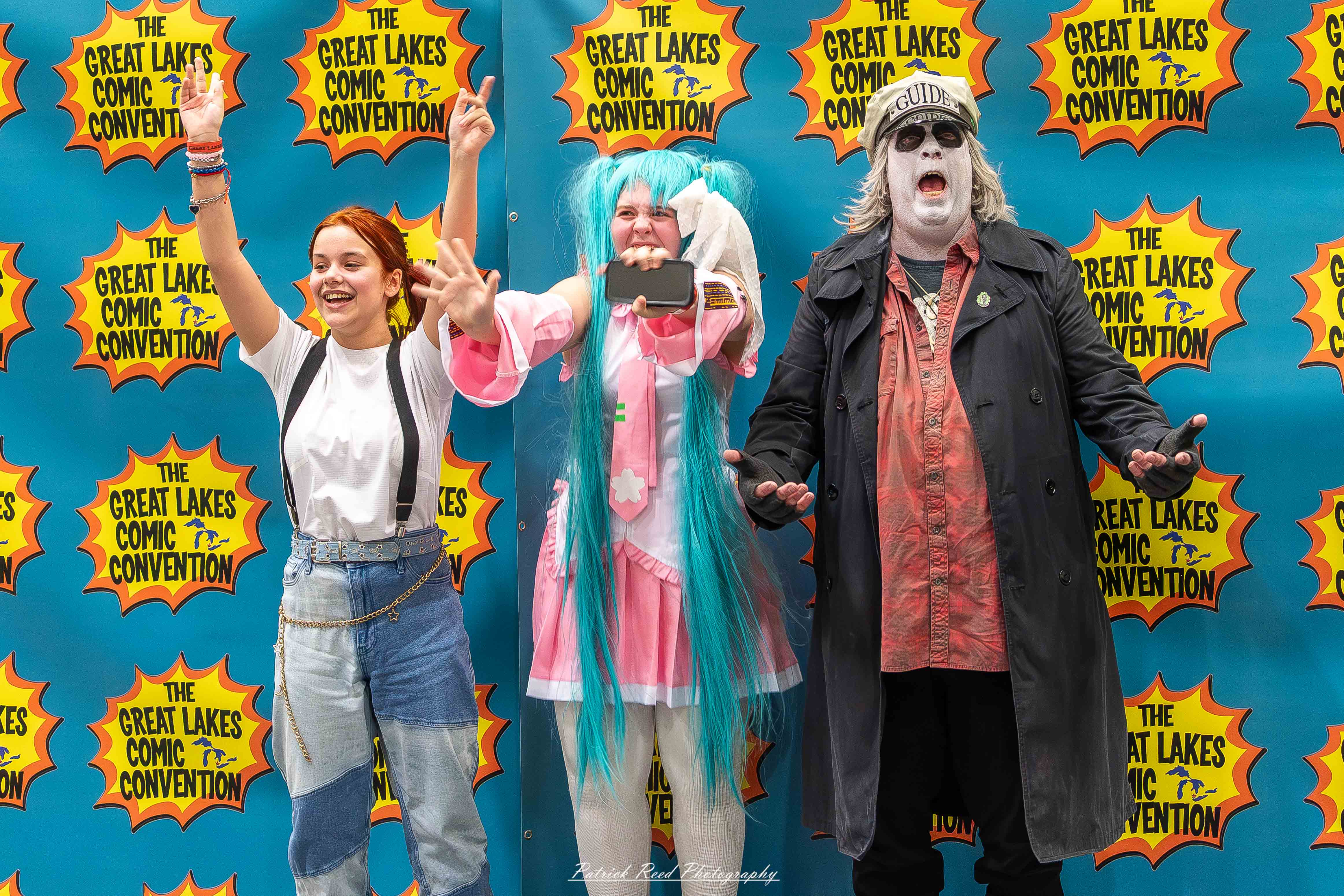 Great Lakes Comic Con 48 Alt text: A group of cosplayers posing on stage at the Great Lakes Comic Con cosplay contest, dressed as various characters from comics, anime, and video games. The audience watches from below as the participants show off their detailed costumes under bright stage lights.