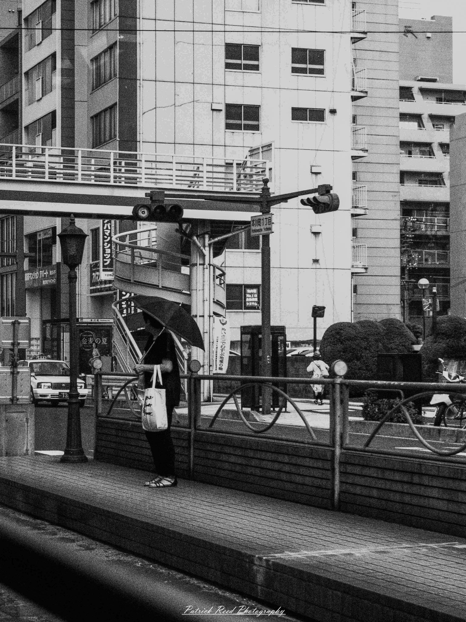 A series of noir-style street photography scenes set in Hiroshima, Japan, at night. The rain-slicked streets and narrow alleys reflect the soft glow of neon signs from izakayas, small shops, and vending machines. Silhouettes of people walking under umbrellas move through the misty atmosphere, their shadows stretching across the pavement. Traditional Japanese architecture, such as wooden facades and noren curtains, blends with modern urban elements like glowing billboards and bicycles parked along dimly lit sidewalks. The moody lighting, deep contrasts, and quiet yet cinematic ambiance evoke a sense of mystery and nostalgia, capturing the noir aesthetic in a contemporary Japanese cityscape.
