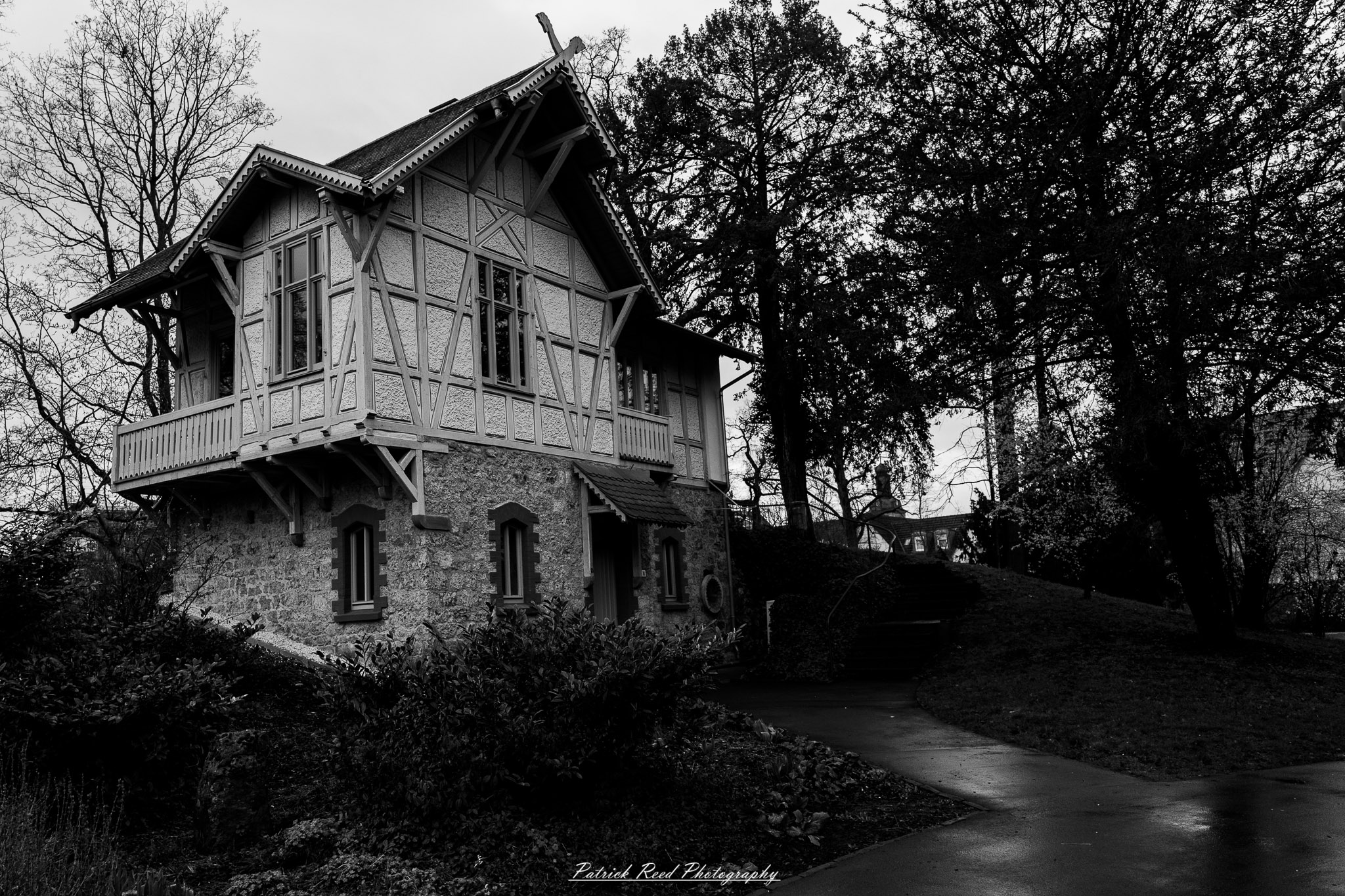 Russelsheim 9 A series of noir-style street photography scenes set in Rüsselsheim, Germany, at night. The dimly lit streets feature wet cobblestones reflecting the glow of streetlights and neon signs. Shadows and silhouettes of people, some walking or riding bicycles, add a mysterious atmosphere. Industrial architecture, such as factory buildings and modern urban structures, contrasts with old-world charm. Elements like parked cars, lampposts, and occasional graffiti create a gritty, cinematic ambiance. The misty air and moody lighting emphasize the noir aesthetic, evoking a sense of intrigue and storytelling.
