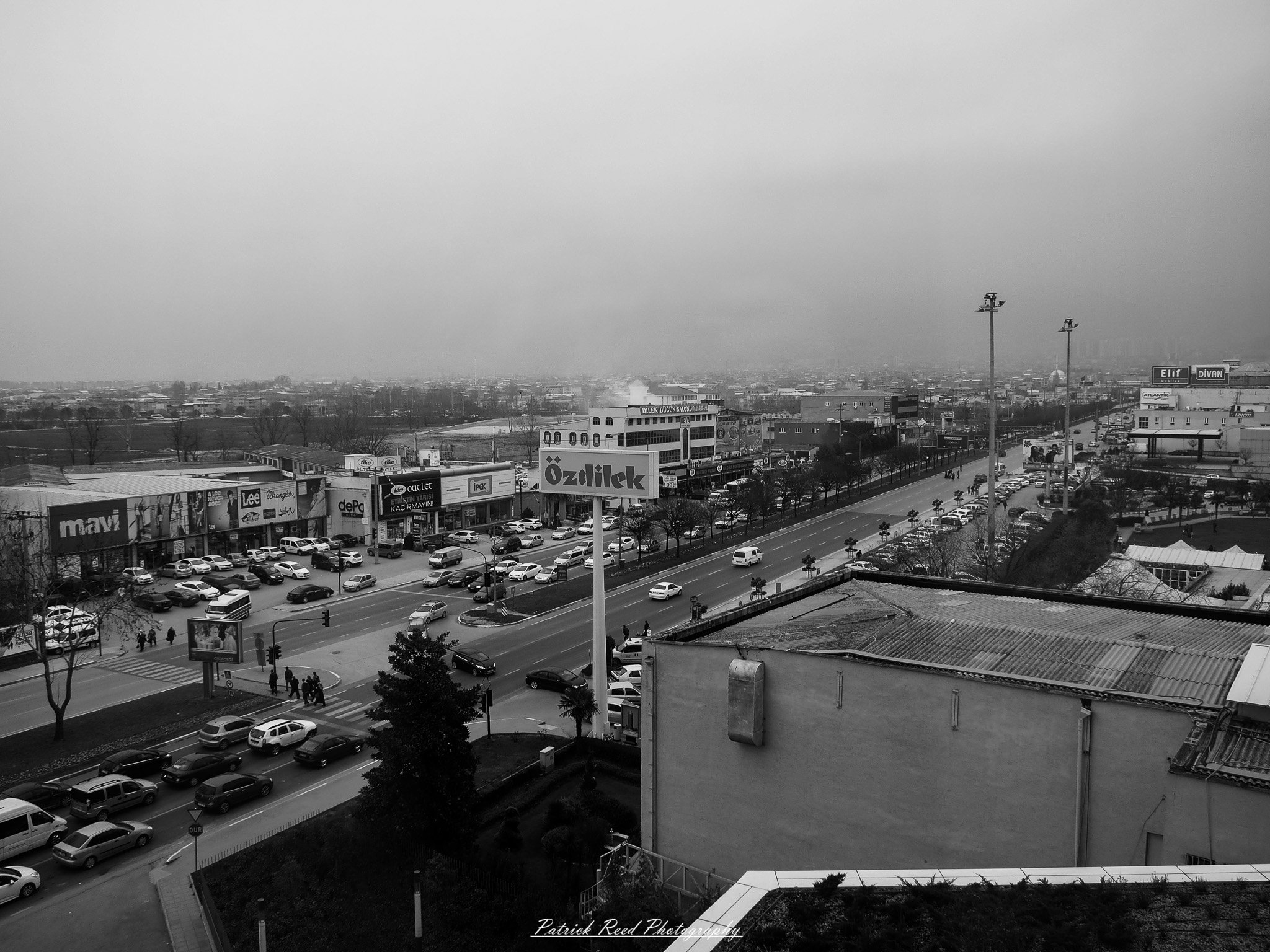 Turkey 1 A series of noir-style street photography scenes set in Istanbul, Turkey, at night. The dimly lit streets and narrow alleys are wet from rain, reflecting the warm glow of streetlights and neon signs. Silhouettes of people walking, some carrying umbrellas, move through the misty atmosphere. The scenes highlight a blend of historical Ottoman architecture, such as arched doorways and intricate stone facades, with modern urban elements like cafes, storefronts, and graffiti. The Bosphorus skyline and glimpses of minarets in the distance add to the cinematic, mysterious ambiance. The overall mood is evocative and steeped in noir storytelling.