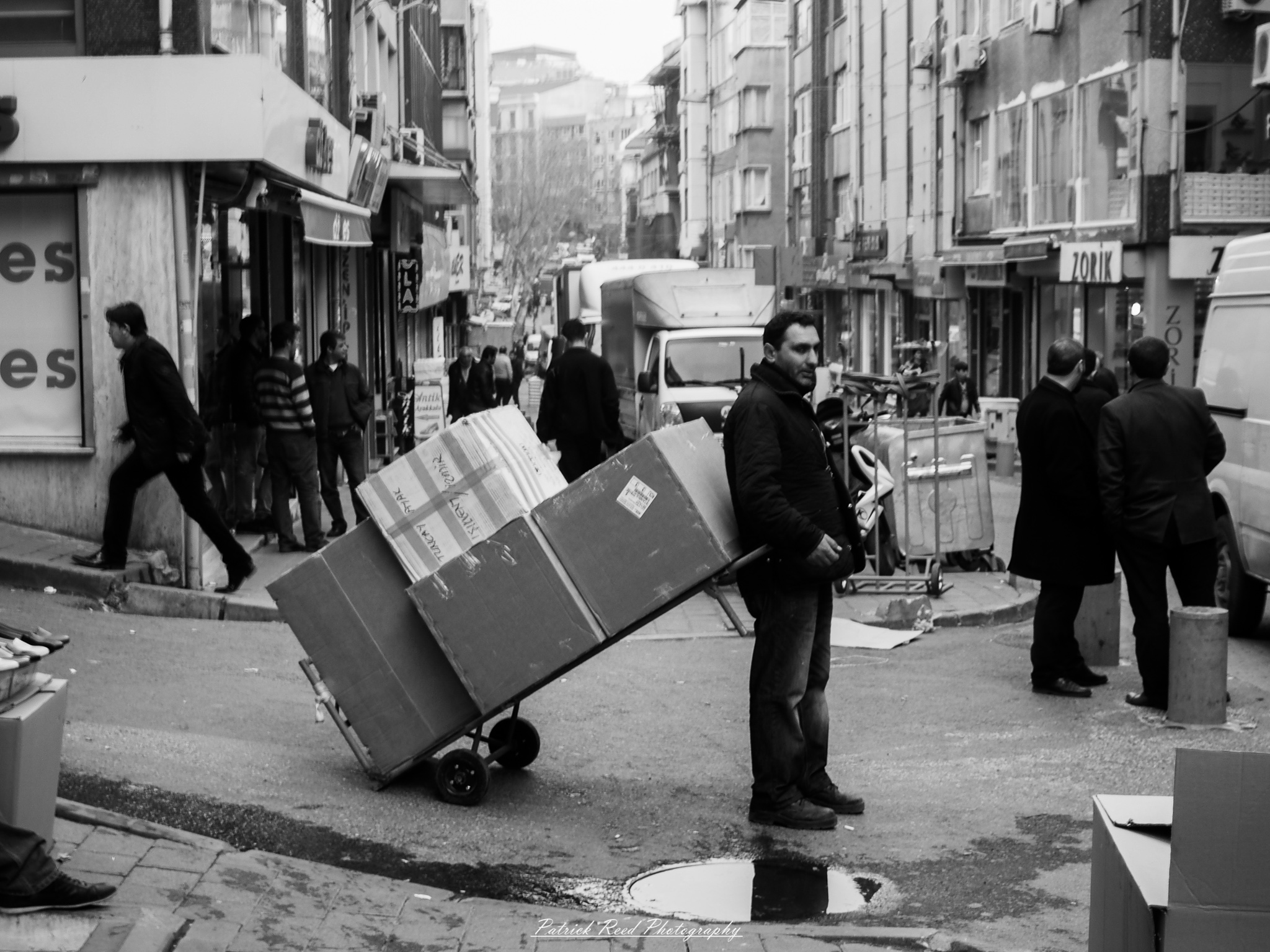 Turkey 14 A series of noir-style street photography scenes set in Istanbul, Turkey, at night. The dimly lit streets and narrow alleys are wet from rain, reflecting the warm glow of streetlights and neon signs. Silhouettes of people walking, some carrying umbrellas, move through the misty atmosphere. The scenes highlight a blend of historical Ottoman architecture, such as arched doorways and intricate stone facades, with modern urban elements like cafes, storefronts, and graffiti. The Bosphorus skyline and glimpses of minarets in the distance add to the cinematic, mysterious ambiance. The overall mood is evocative and steeped in noir storytelling.