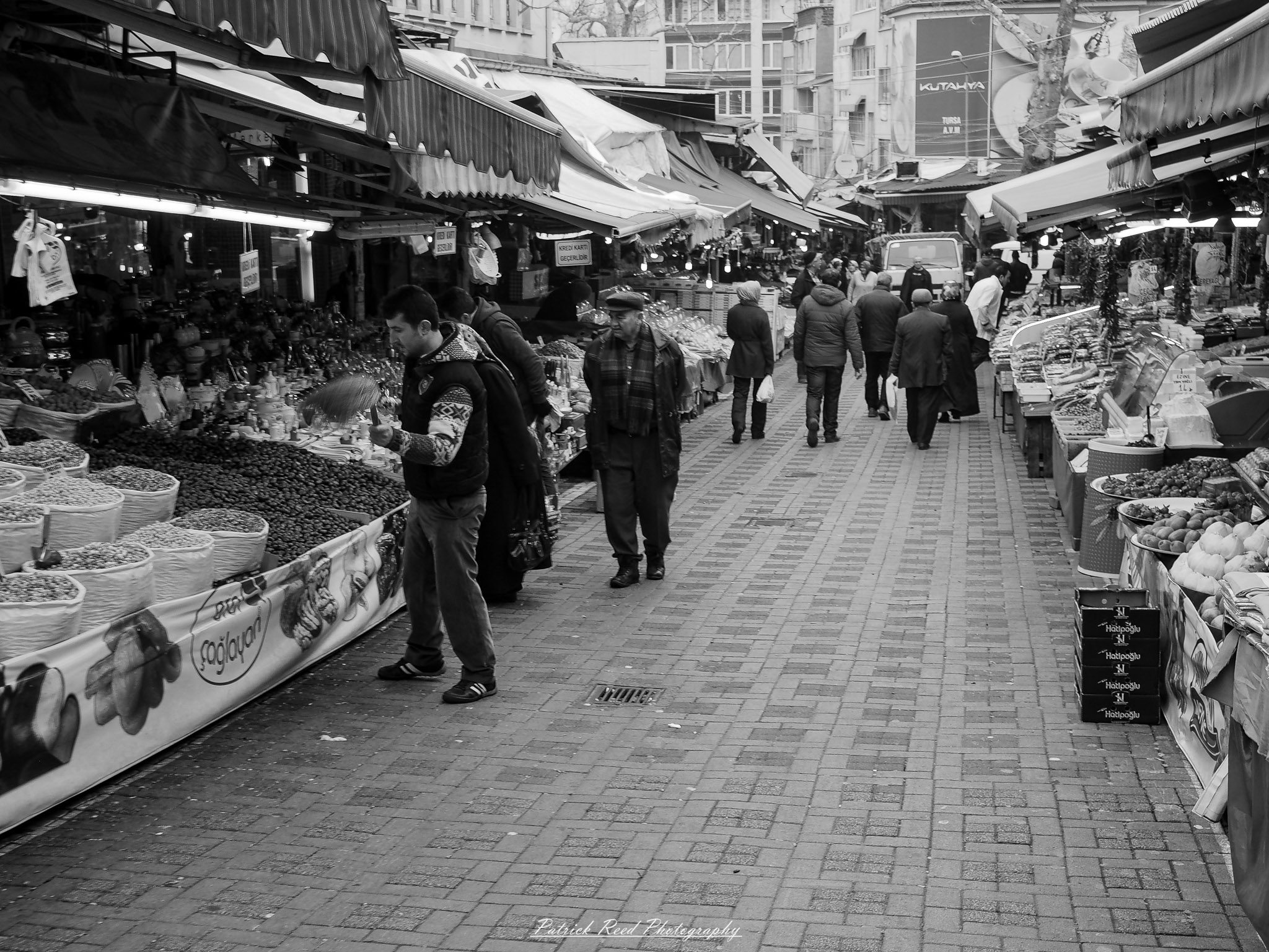 Turkey 3 A series of noir-style street photography scenes set in Istanbul, Turkey, at night. The dimly lit streets and narrow alleys are wet from rain, reflecting the warm glow of streetlights and neon signs. Silhouettes of people walking, some carrying umbrellas, move through the misty atmosphere. The scenes highlight a blend of historical Ottoman architecture, such as arched doorways and intricate stone facades, with modern urban elements like cafes, storefronts, and graffiti. The Bosphorus skyline and glimpses of minarets in the distance add to the cinematic, mysterious ambiance. The overall mood is evocative and steeped in noir storytelling.