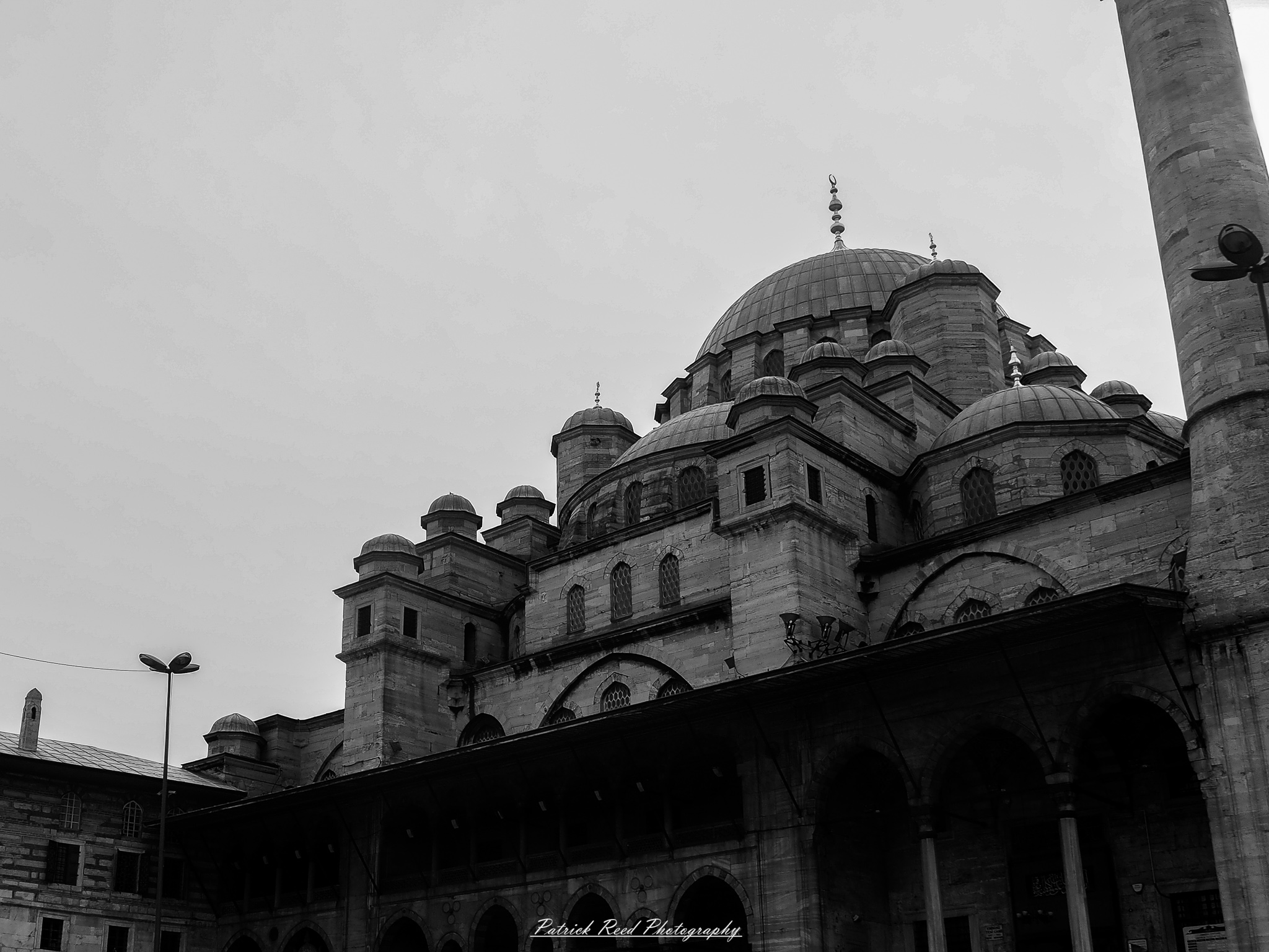 Turkey 6 A series of noir-style street photography scenes set in Istanbul, Turkey, at night. The dimly lit streets and narrow alleys are wet from rain, reflecting the warm glow of streetlights and neon signs. Silhouettes of people walking, some carrying umbrellas, move through the misty atmosphere. The scenes highlight a blend of historical Ottoman architecture, such as arched doorways and intricate stone facades, with modern urban elements like cafes, storefronts, and graffiti. The Bosphorus skyline and glimpses of minarets in the distance add to the cinematic, mysterious ambiance. The overall mood is evocative and steeped in noir storytelling.