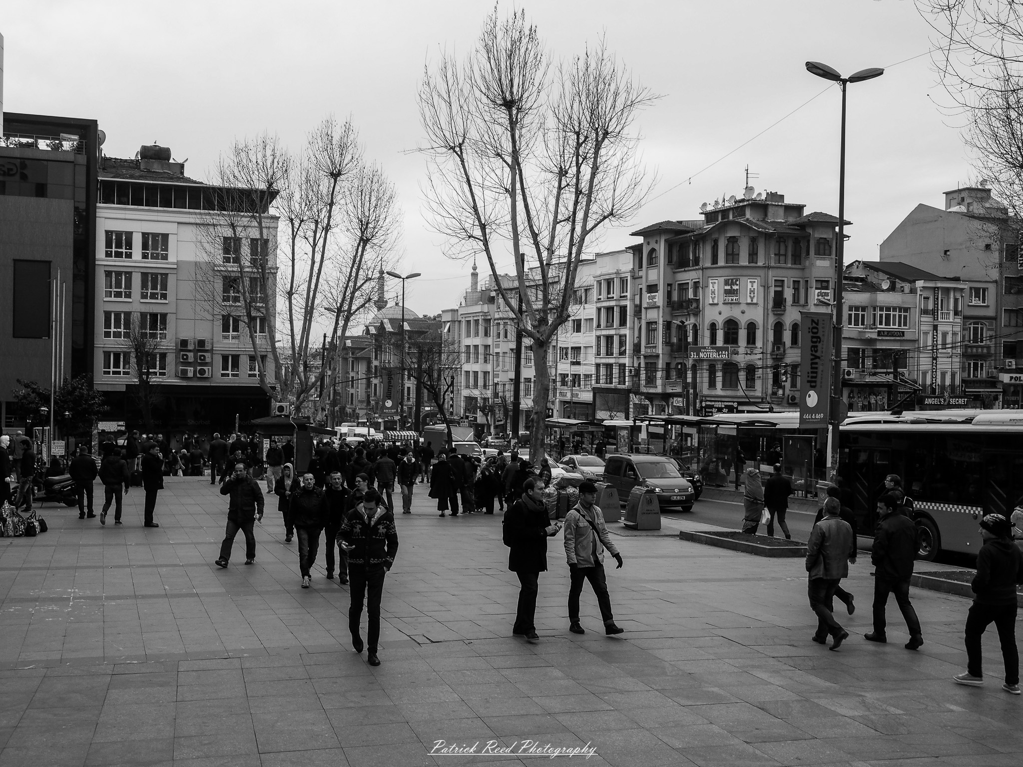 Turkey 8 A series of noir-style street photography scenes set in Istanbul, Turkey, at night. The dimly lit streets and narrow alleys are wet from rain, reflecting the warm glow of streetlights and neon signs. Silhouettes of people walking, some carrying umbrellas, move through the misty atmosphere. The scenes highlight a blend of historical Ottoman architecture, such as arched doorways and intricate stone facades, with modern urban elements like cafes, storefronts, and graffiti. The Bosphorus skyline and glimpses of minarets in the distance add to the cinematic, mysterious ambiance. The overall mood is evocative and steeped in noir storytelling.