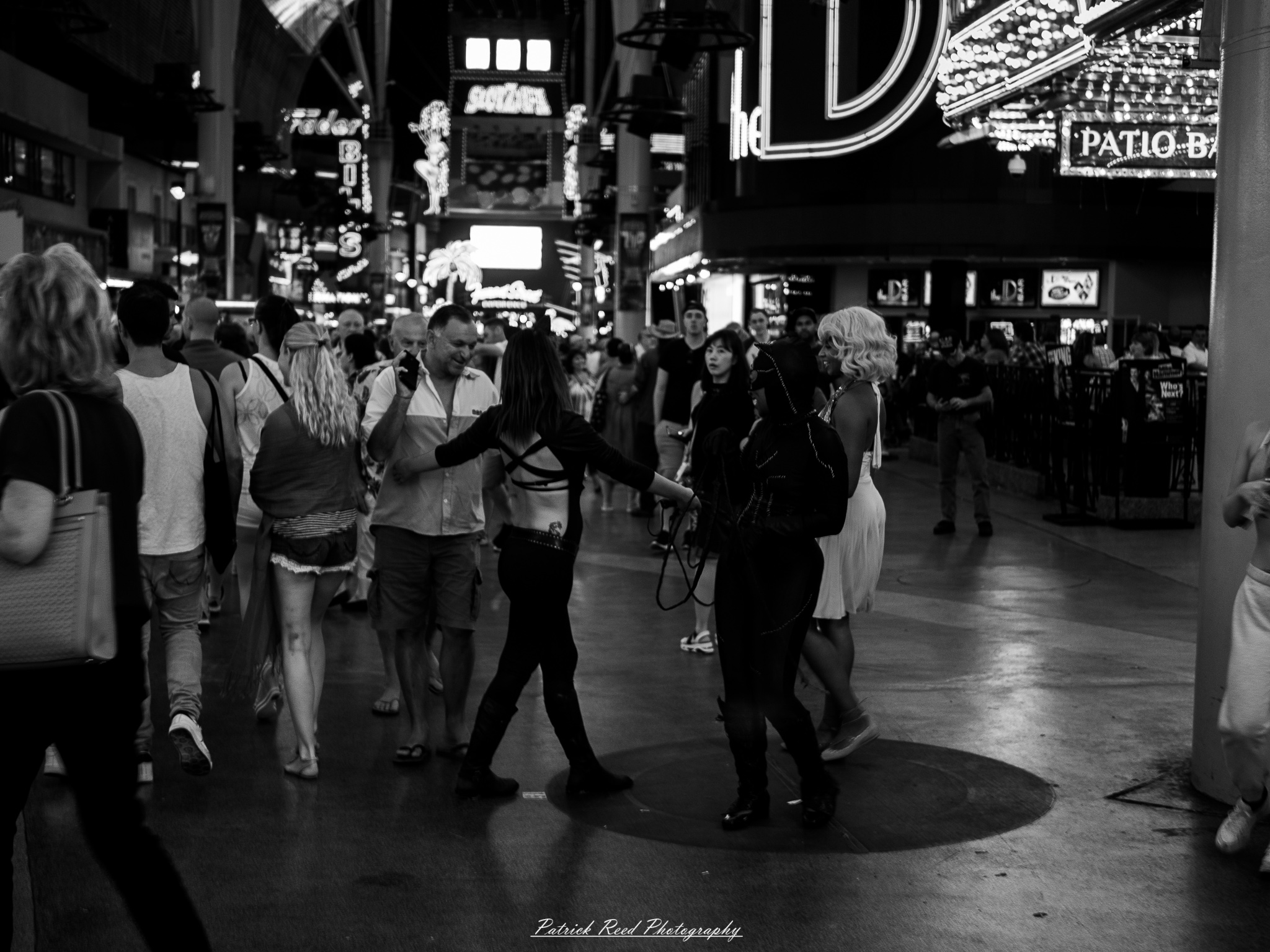 Vegas 18 A series of noir-style street photography scenes set in Las Vegas, Nevada, at night. The rain-slicked streets reflect the vibrant glow of neon signs from casinos, motels, and diners. Silhouettes of people walking under umbrellas or leaning against lampposts add a sense of mystery and intrigue. The scenes capture a mix of classic Vegas landmarks, vintage signage, and gritty back alleys with graffiti and scattered debris. The dramatic lighting emphasizes shadows and contrasts, creating a moody, cinematic ambiance that evokes the essence of noir storytelling in a bustling yet shadowy cityscape.