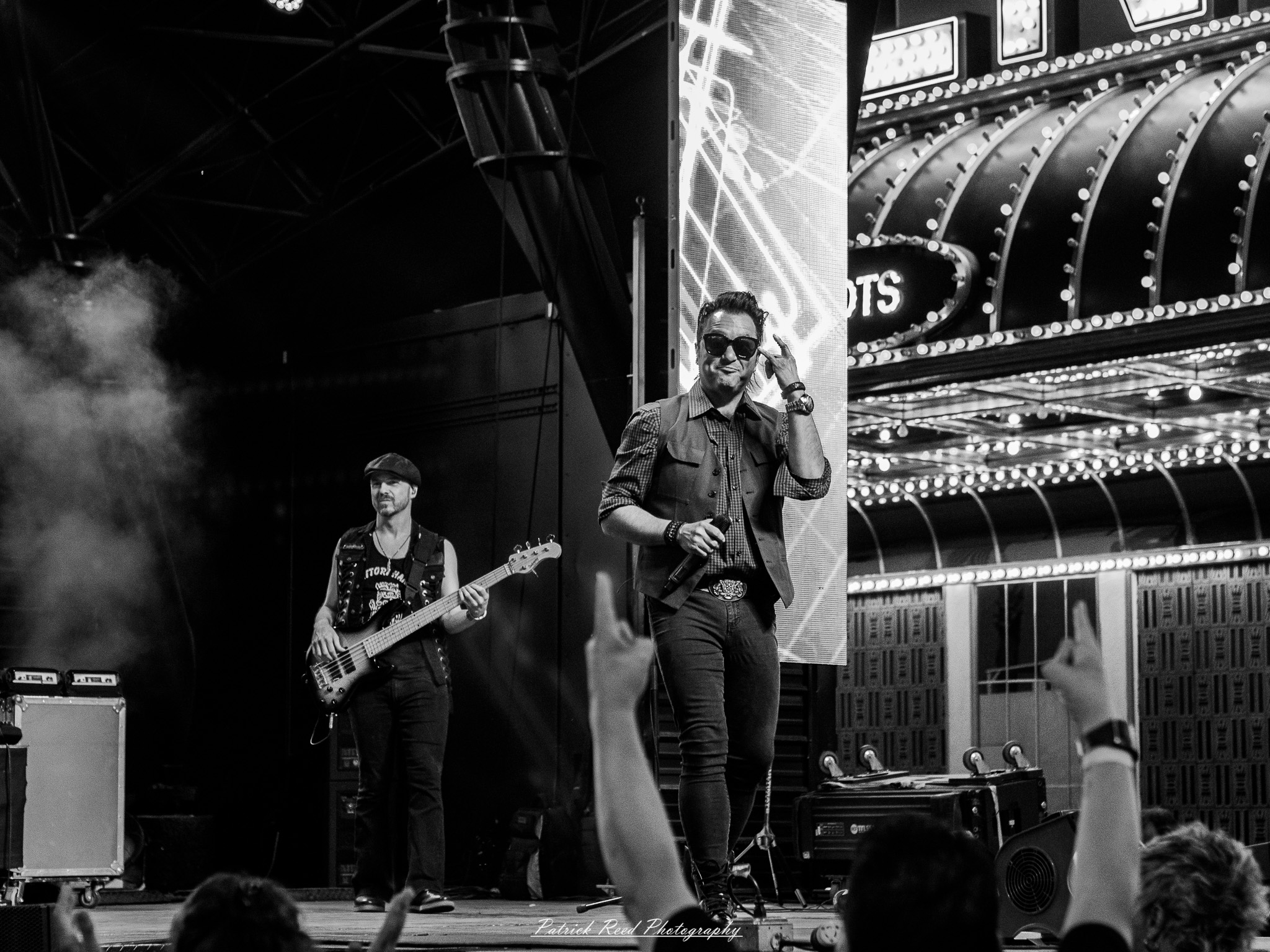 Vegas Street Photograph 1 A series of noir-style street photography scenes set in Las Vegas, Nevada, at night. The rain-slicked streets reflect the vibrant glow of neon signs from casinos, motels, and diners. Silhouettes of people walking under umbrellas or leaning against lampposts add a sense of mystery and intrigue. The scenes capture a mix of classic Vegas landmarks, vintage signage, and gritty back alleys with graffiti and scattered debris. The dramatic lighting emphasizes shadows and contrasts, creating a moody, cinematic ambiance that evokes the essence of noir storytelling in a bustling yet shadowy cityscape.