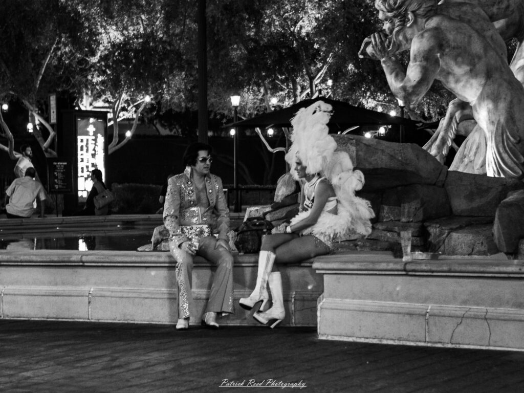 A series of noir-style street photography scenes set in Las Vegas, Nevada, at night. The rain-slicked streets reflect the vibrant glow of neon signs from casinos, motels, and diners. Silhouettes of people walking under umbrellas or leaning against lampposts add a sense of mystery and intrigue. The scenes capture a mix of classic Vegas landmarks, vintage signage, and gritty back alleys with graffiti and scattered debris. The dramatic lighting emphasizes shadows and contrasts, creating a moody, cinematic ambiance that evokes the essence of noir storytelling in a bustling yet shadowy cityscape.