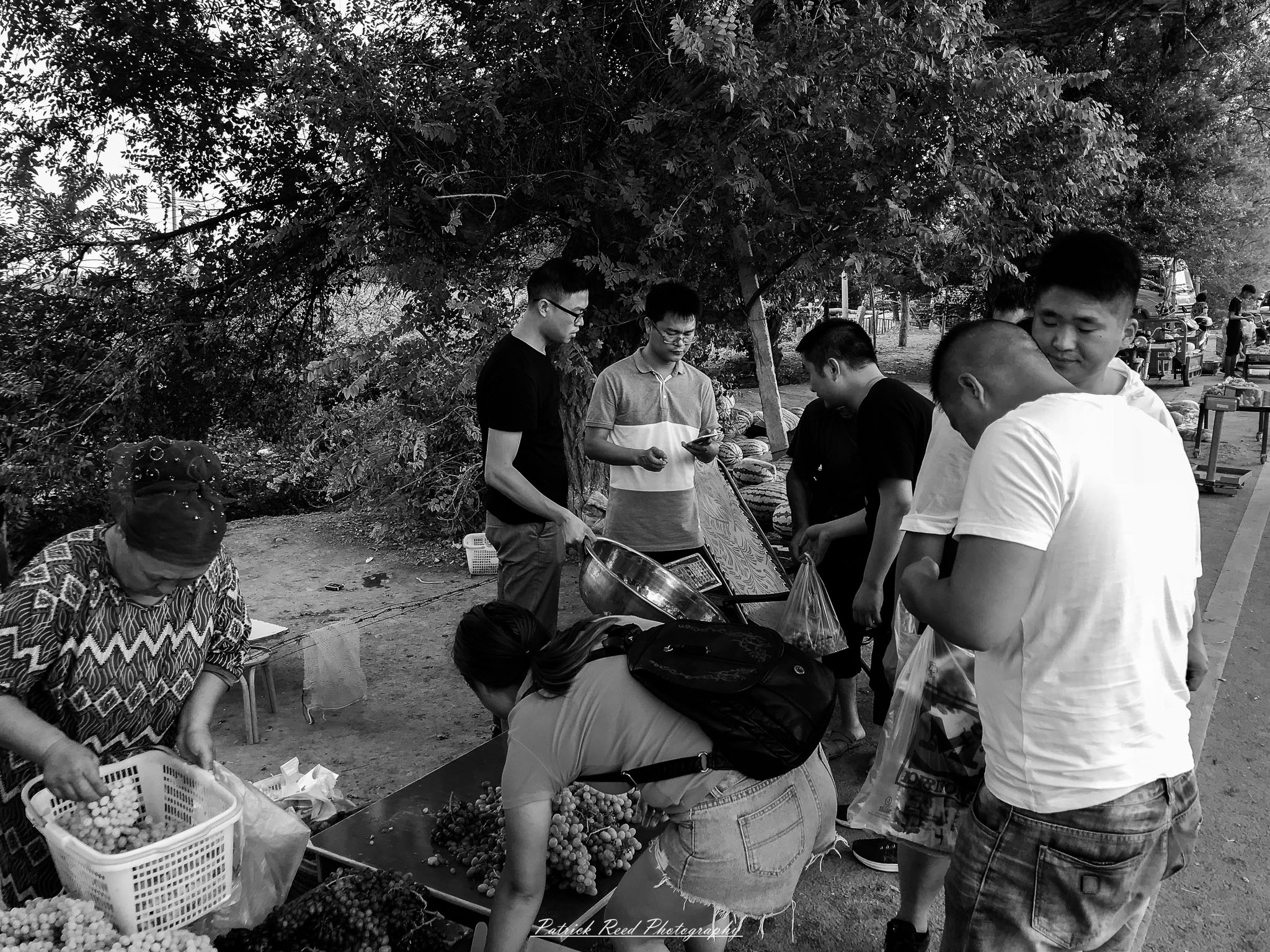 A series of noir-style street photography scenes set in Dunhuang, China, at night. The dimly lit streets and narrow alleyways reflect the soft glow of lanterns and neon signs from small shops and market stalls. Silhouettes of people walk through the misty night, some in traditional robes, adding a sense of mystery. The historic Silk Road atmosphere is highlighted by earthen architecture, intricate wooden doors, and desert dust settling on the pavement. Modern elements like motorbikes and distant headlights contrast with the ancient setting. The deep shadows and warm, flickering lights create a cinematic, moody ambiance, blending noir aesthetics with Dunhuang’s rich cultural history.