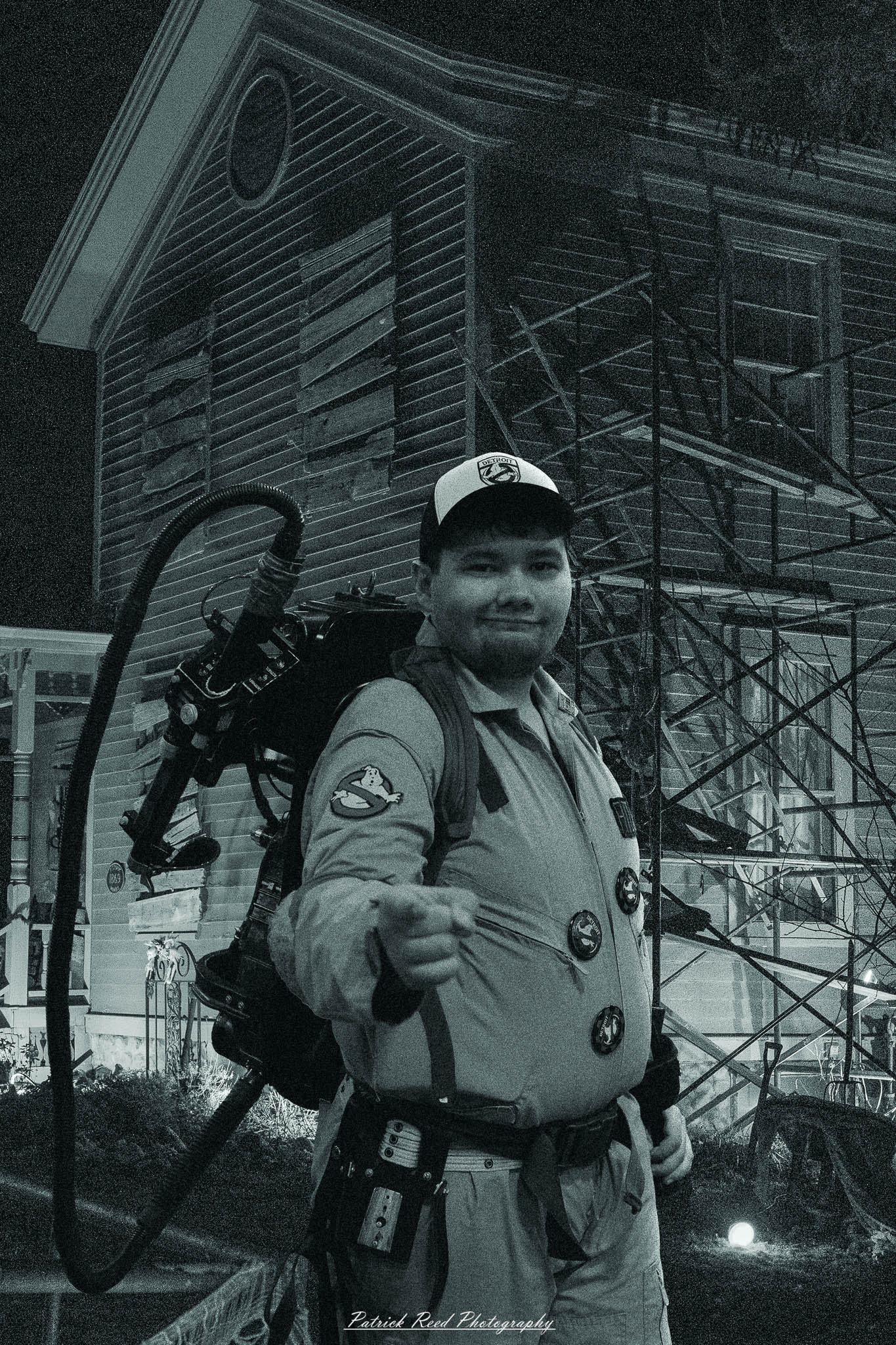Ghostbuster in front of a haunted house