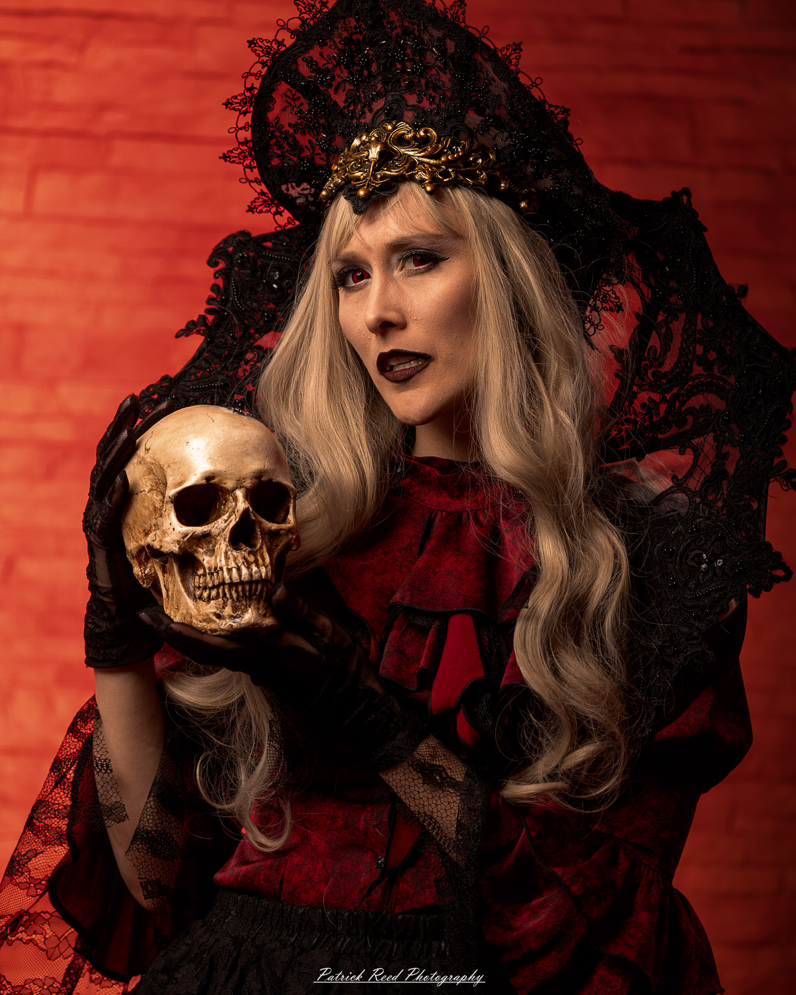 Portrait of a woman in vampire cosplay named Lady Thorn, photographed on June 28, 2025. She is posed against a vivid red background, styled with gothic elements and dramatic expression.