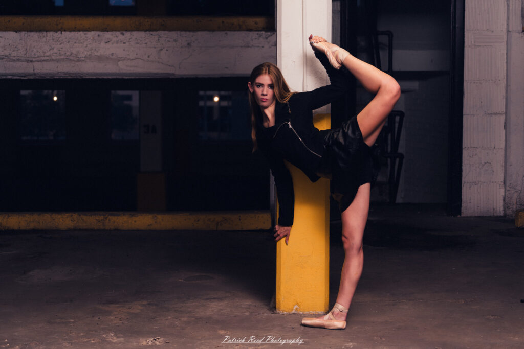 Portrait of a ballet dancer photographed on July 30, 2025, in a parking garage in Pontiac, Michigan. The dancer strikes a poised, elegant pose against the gritty urban backdrop.