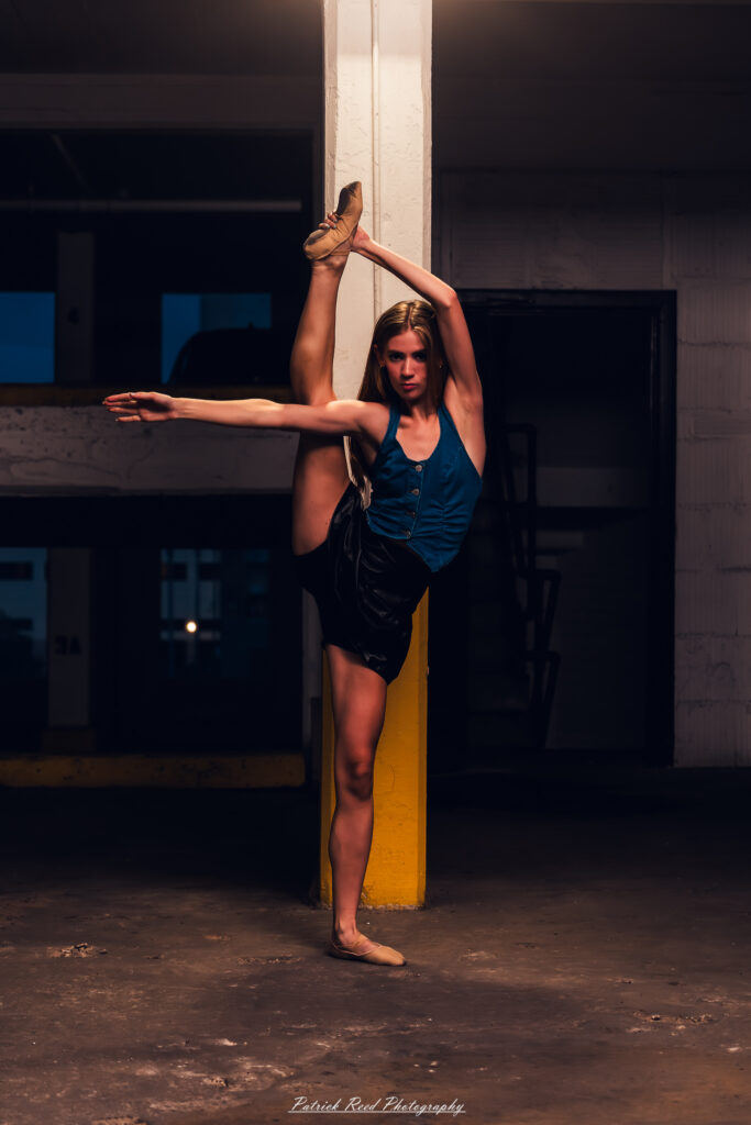 Portrait of a ballet dancer photographed on July 30, 2025, in a parking garage in Pontiac, Michigan. The dancer strikes a poised, elegant pose against the gritty urban backdrop.