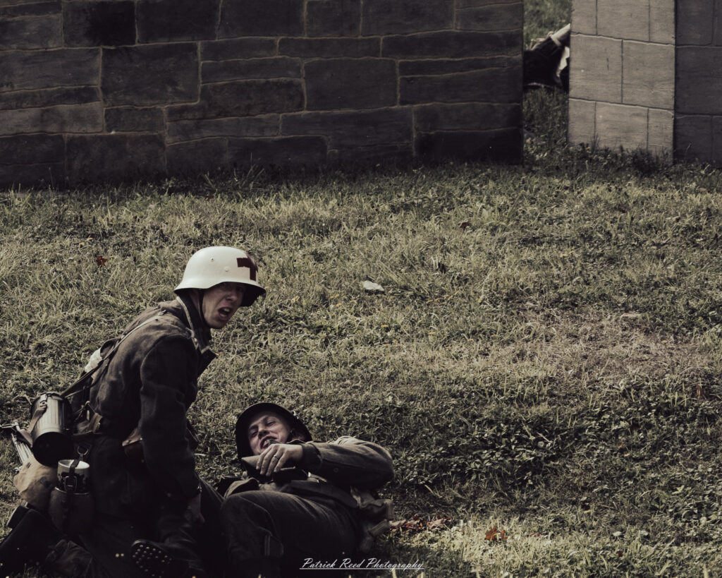 A group of World War II reenactors in period-accurate uniforms—American, German, and French Resistance—on a sandy shore during the D-Day Conneaut 2025 reenactment at Conneaut Township Park, Ohio.