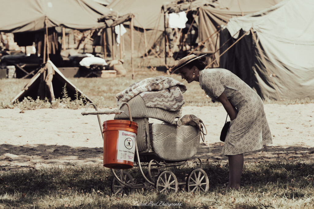 A group of World War II reenactors in period-accurate uniforms—American, German, and French Resistance—on a sandy shore during the D-Day Conneaut 2025 reenactment at Conneaut Township Park, Ohio.