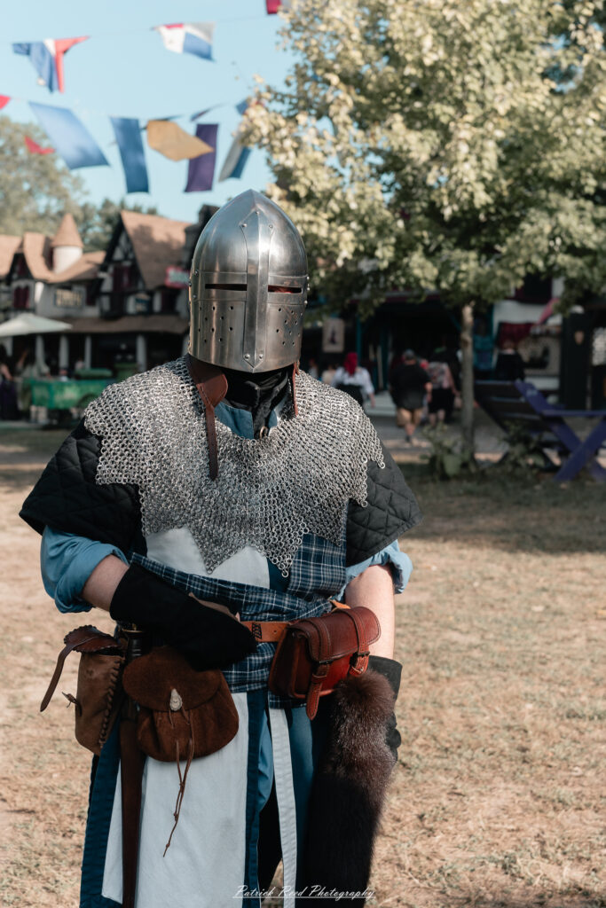 A costumed performer at the Michigan Renaissance Festival 2025, wearing traditional Renaissance attire during a live event in Holly, Michigan.