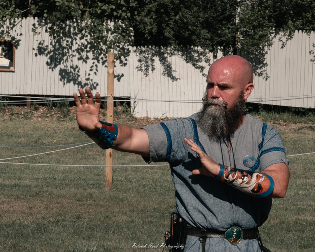 A costumed performer at the Michigan Renaissance Festival 2025, wearing traditional Renaissance attire during a live event in Holly, Michigan.