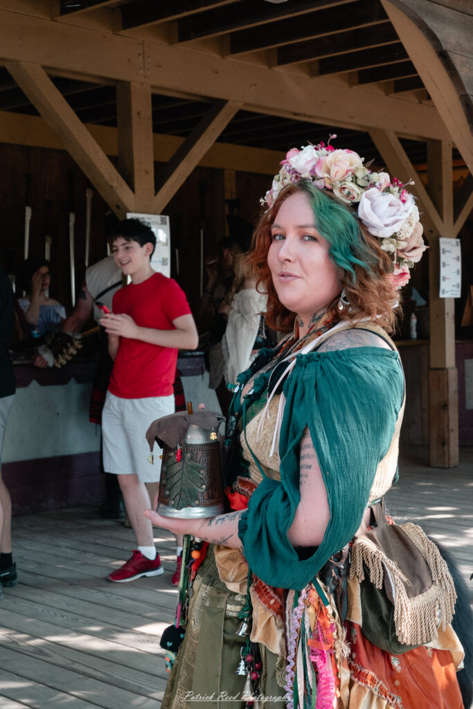A costumed performer at the Michigan Renaissance Festival 2025, wearing traditional Renaissance attire during a live event in Holly, Michigan.