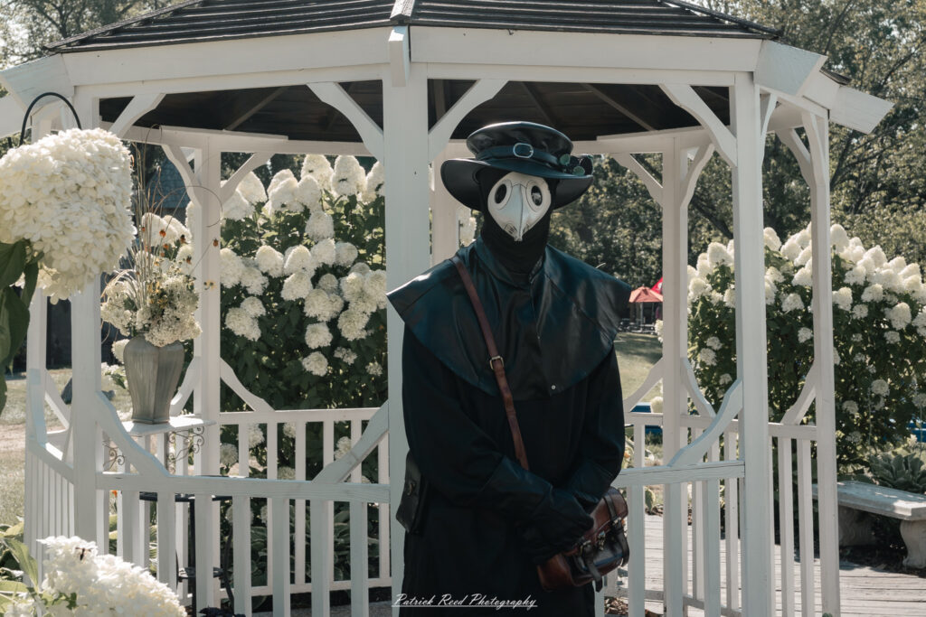 A costumed performer at the Michigan Renaissance Festival 2025, wearing traditional Renaissance attire during a live event in Holly, Michigan.