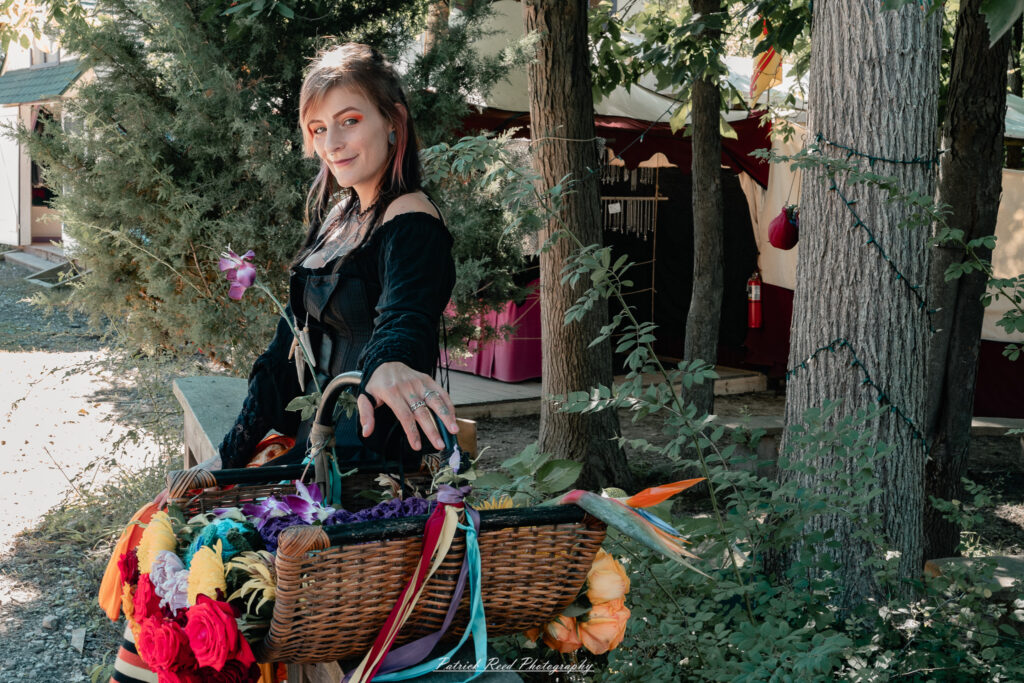 A costumed performer at the Michigan Renaissance Festival 2025, wearing traditional Renaissance attire during a live event in Holly, Michigan.