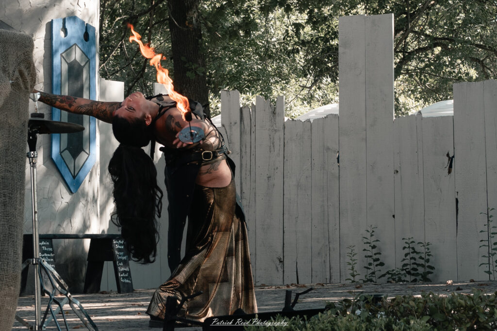 A costumed performer at the Michigan Renaissance Festival 2025, wearing traditional Renaissance attire during a live event in Holly, Michigan.