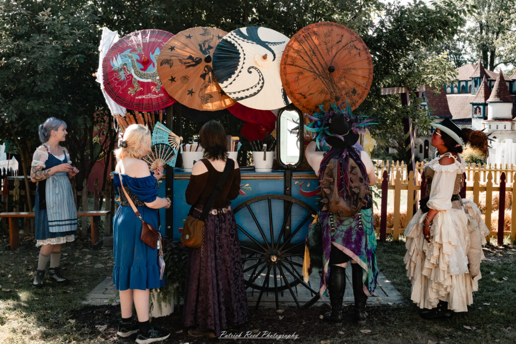 A costumed performer at the Michigan Renaissance Festival 2025, wearing traditional Renaissance attire during a live event in Holly, Michigan.