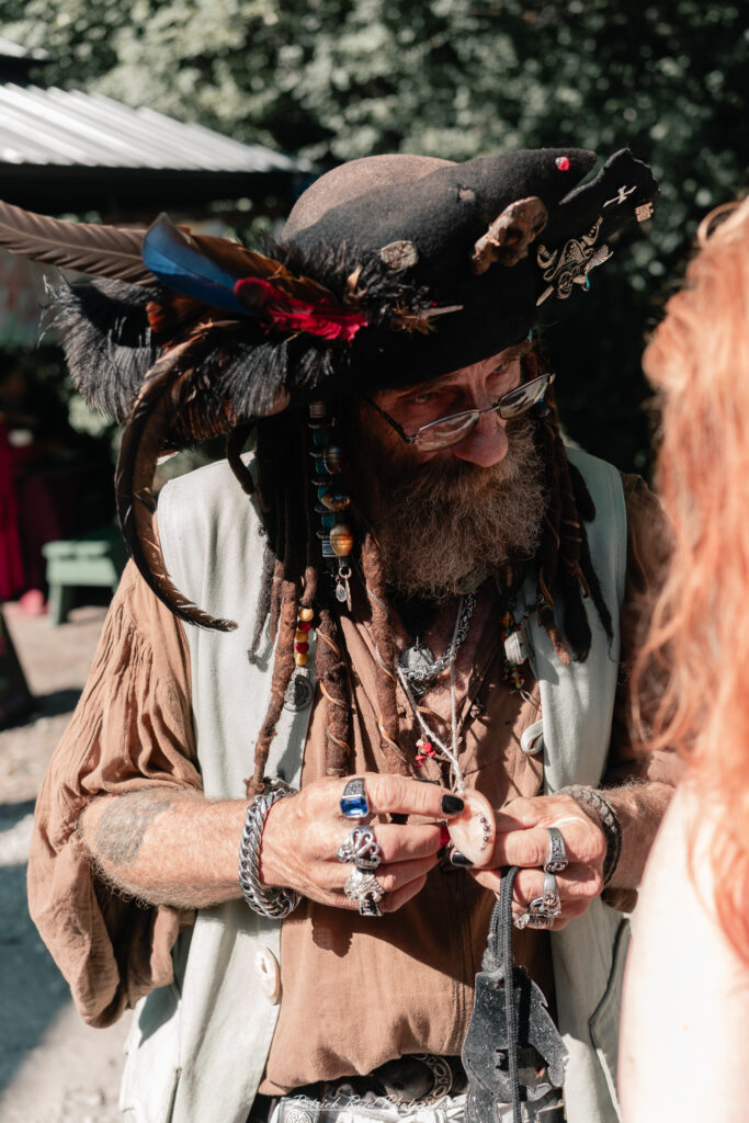 A costumed performer at the Michigan Renaissance Festival 2025, wearing traditional Renaissance attire during a live event in Holly, Michigan.