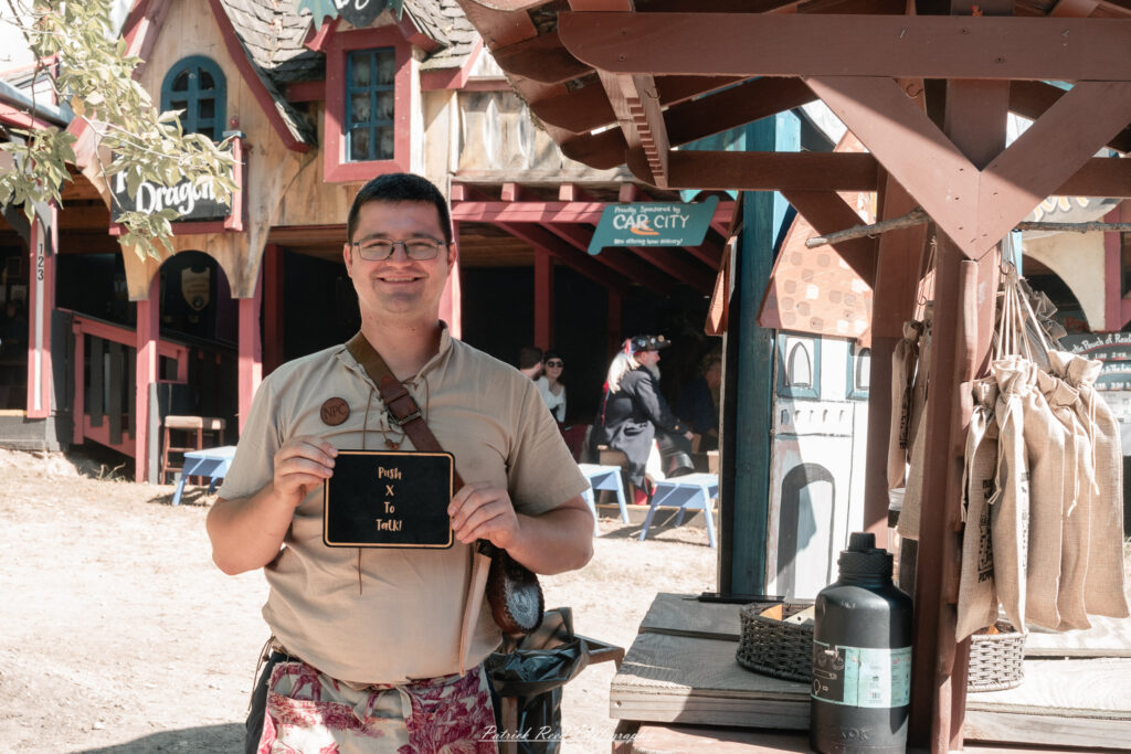 A costumed performer at the Michigan Renaissance Festival 2025, wearing traditional Renaissance attire during a live event in Holly, Michigan.