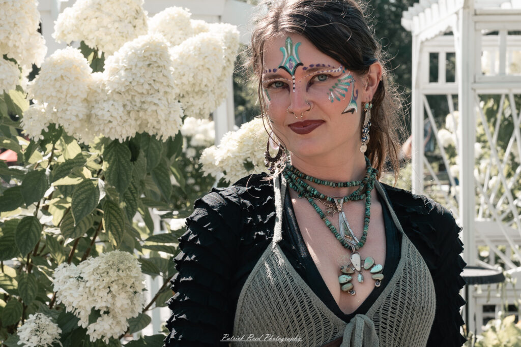 A costumed performer at the Michigan Renaissance Festival 2025, wearing traditional Renaissance attire during a live event in Holly, Michigan.