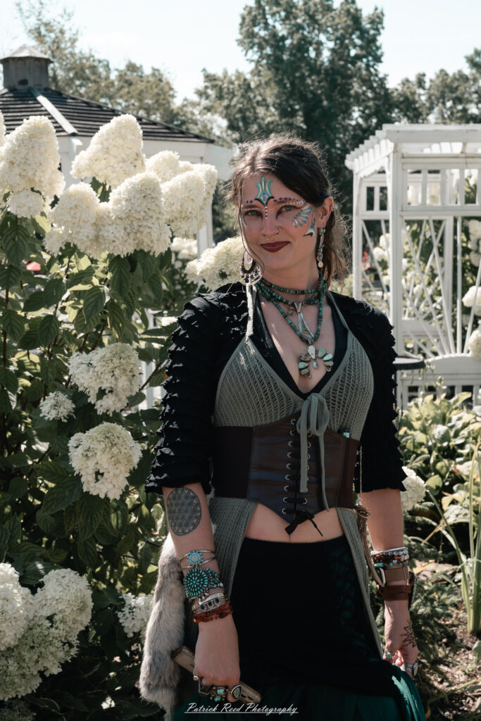 A costumed performer at the Michigan Renaissance Festival 2025, wearing traditional Renaissance attire during a live event in Holly, Michigan.