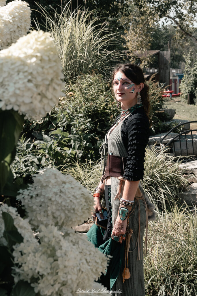 A costumed performer at the Michigan Renaissance Festival 2025, wearing traditional Renaissance attire during a live event in Holly, Michigan.