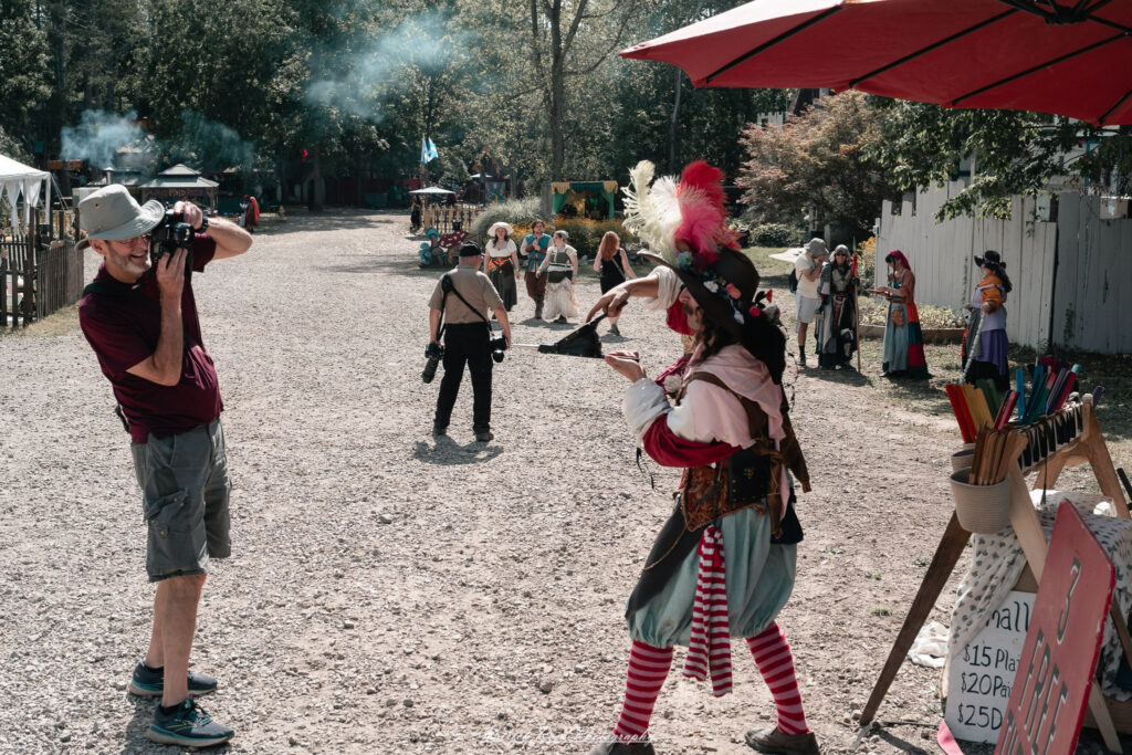 A costumed performer at the Michigan Renaissance Festival 2025, wearing traditional Renaissance attire during a live event in Holly, Michigan.