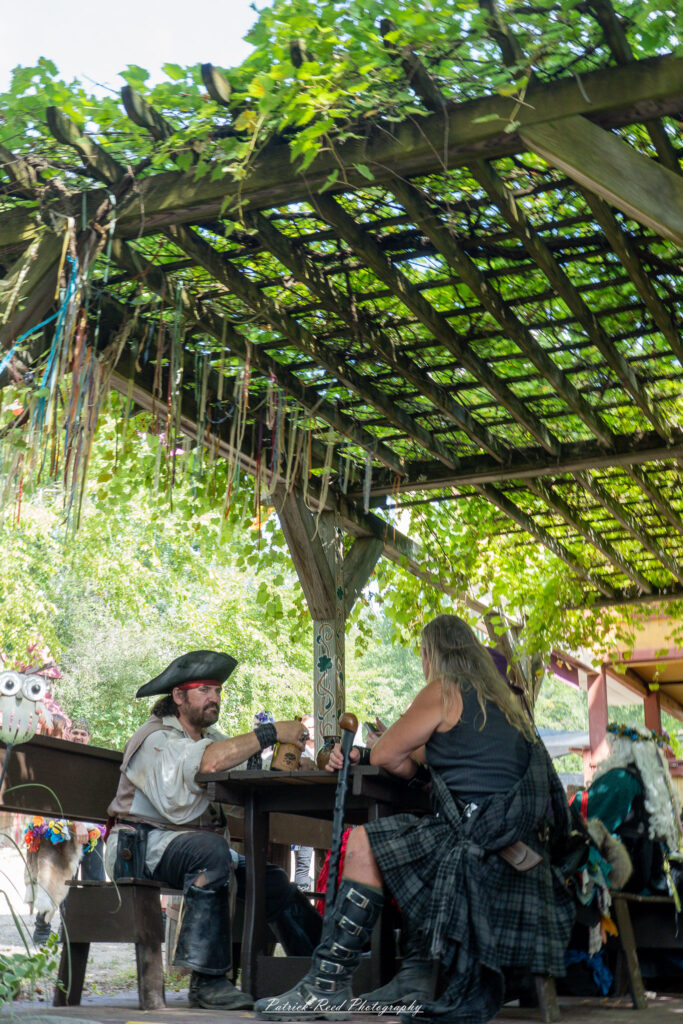 A costumed performer at the Michigan Renaissance Festival 2025, wearing traditional Renaissance attire during a live event in Holly, Michigan.
