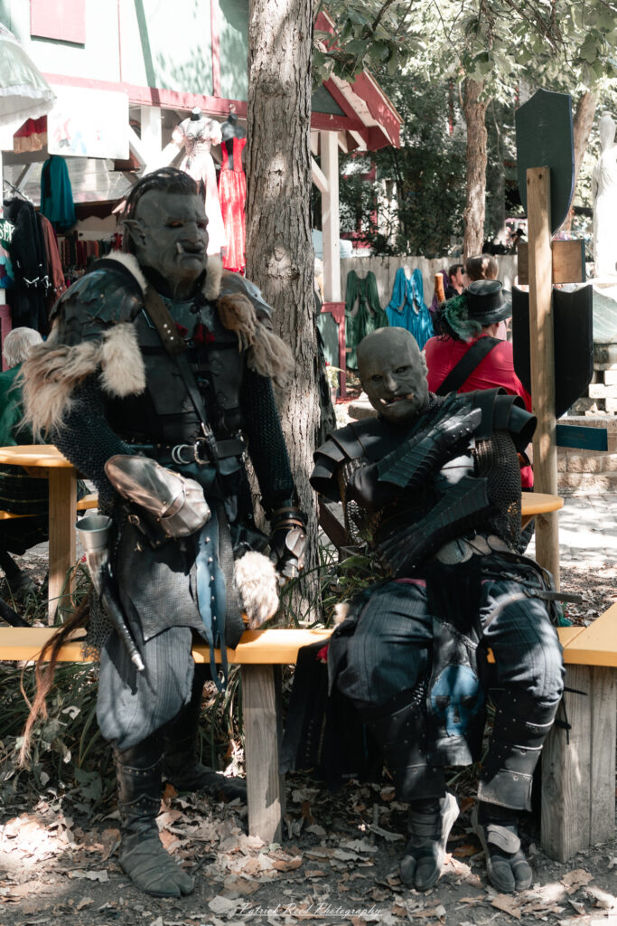 A costumed performer at the Michigan Renaissance Festival 2025, wearing traditional Renaissance attire during a live event in Holly, Michigan.