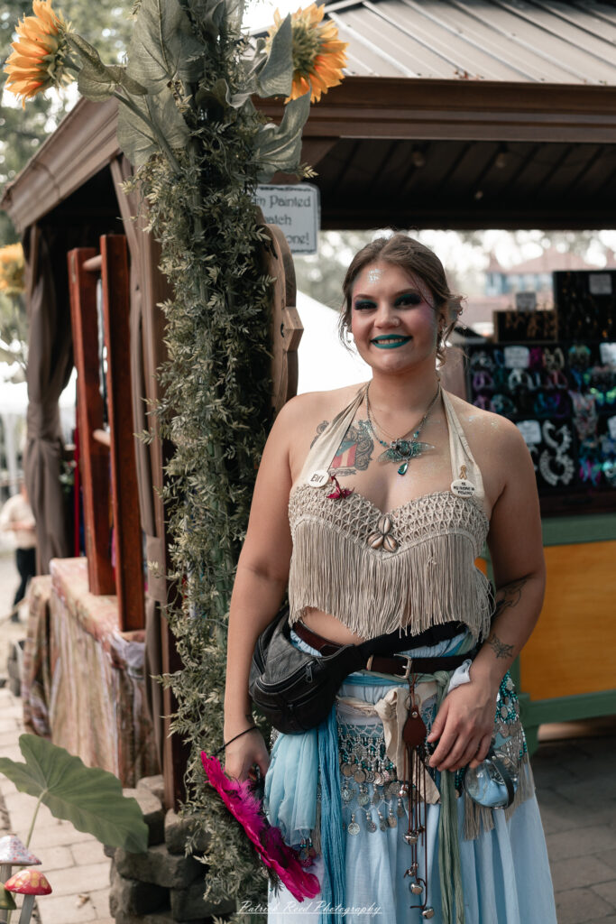 A costumed performer at the Michigan Renaissance Festival 2025, wearing traditional Renaissance attire during a live event in Holly, Michigan.