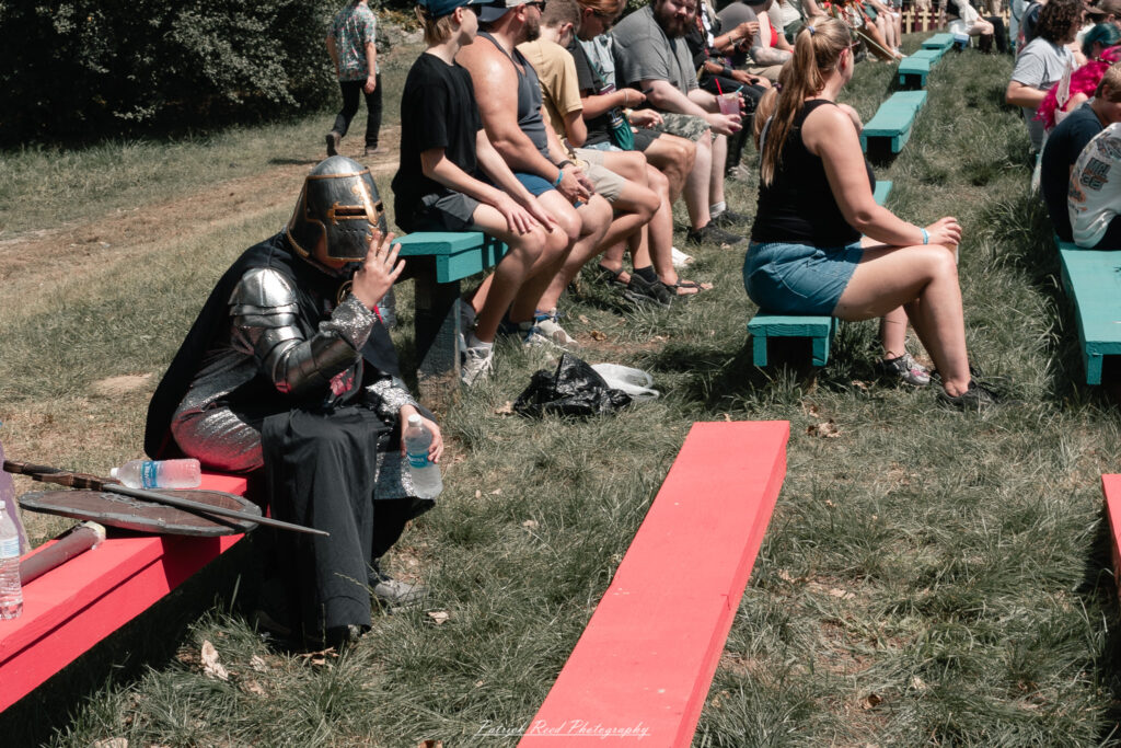 A costumed performer at the Michigan Renaissance Festival 2025, wearing traditional Renaissance attire during a live event in Holly, Michigan.