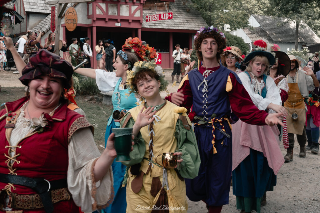 A costumed performer at the Michigan Renaissance Festival 2025, wearing traditional Renaissance attire during a live event in Holly, Michigan.