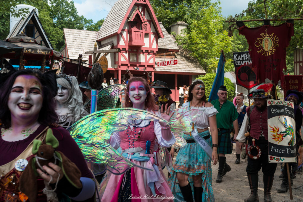 A costumed performer at the Michigan Renaissance Festival 2025, wearing traditional Renaissance attire during a live event in Holly, Michigan.