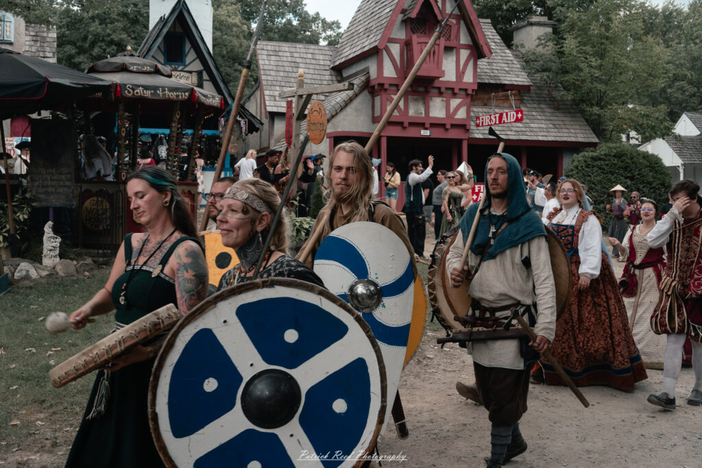 A costumed performer at the Michigan Renaissance Festival 2025, wearing traditional Renaissance attire during a live event in Holly, Michigan.
